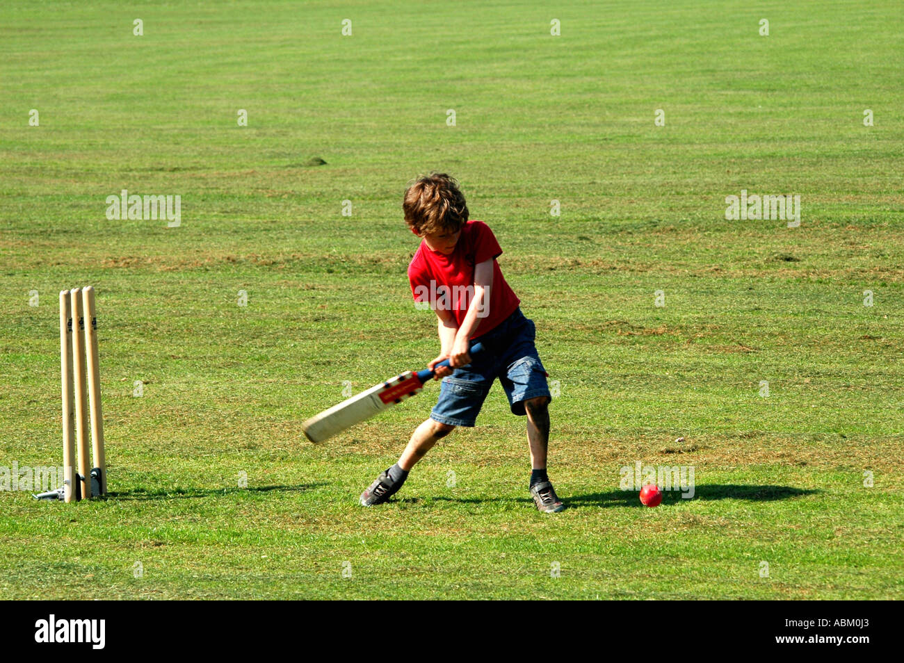 kleiner Junge mit der Wimper in ein Spiel der Cricket im park Stockfoto