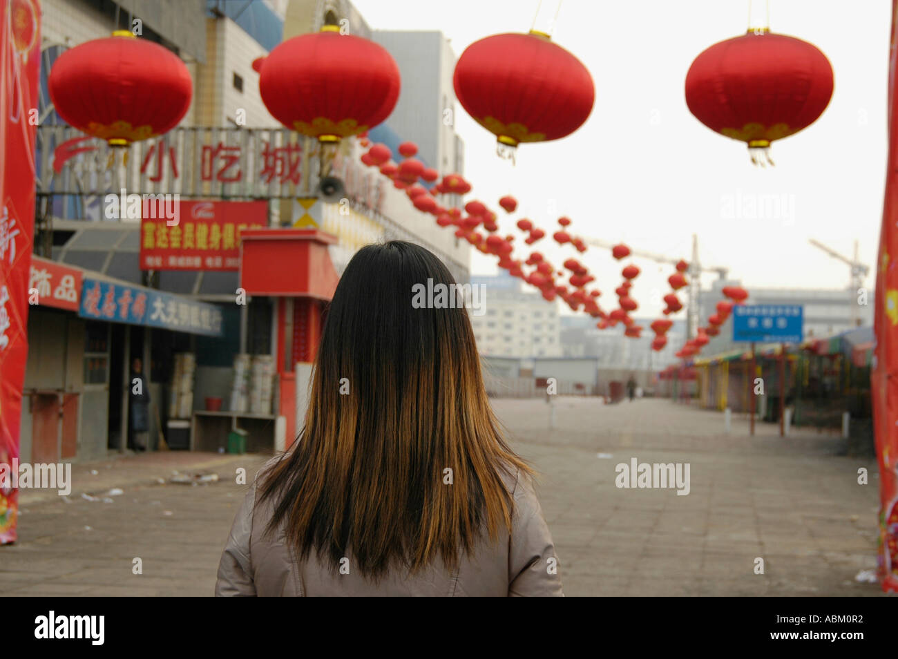 Mädchen auf der Suche zu einer leeren Straße für neue chinesische Jahr Nordchina dekoriert Stockfoto