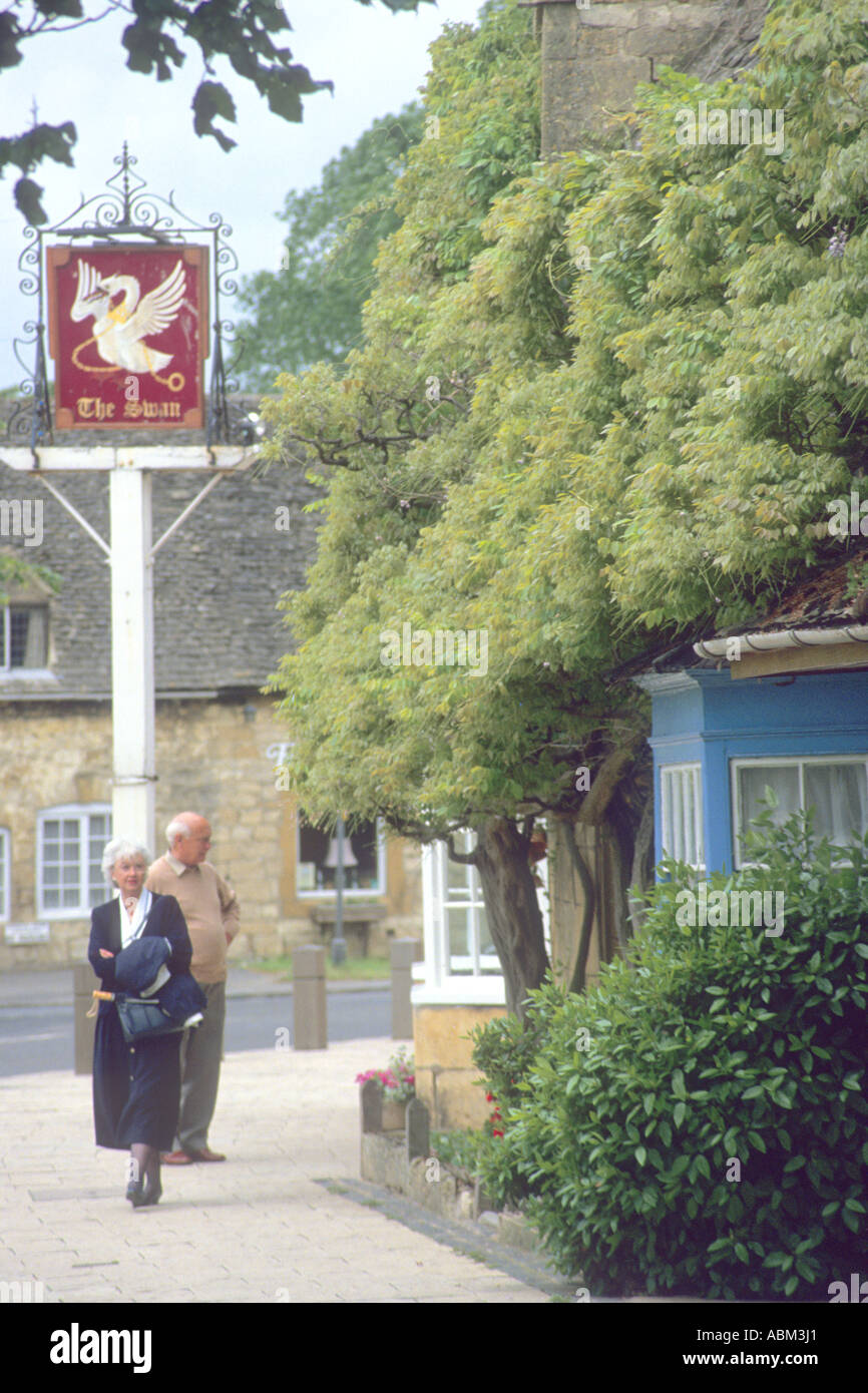 Touristen außerhalb der traditionellen britischen Pub-der Schwan--in der viel besuchten Stadt, Broadway in der Cotswalds Stockfoto