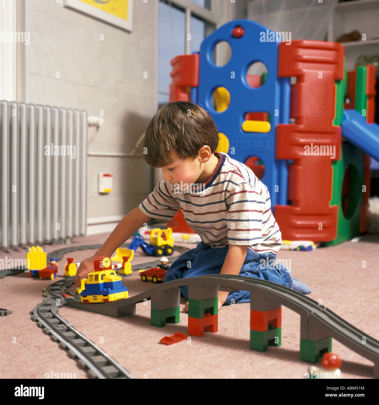 Junge spielt mit einer Spielzeugeisenbahn Stockfoto