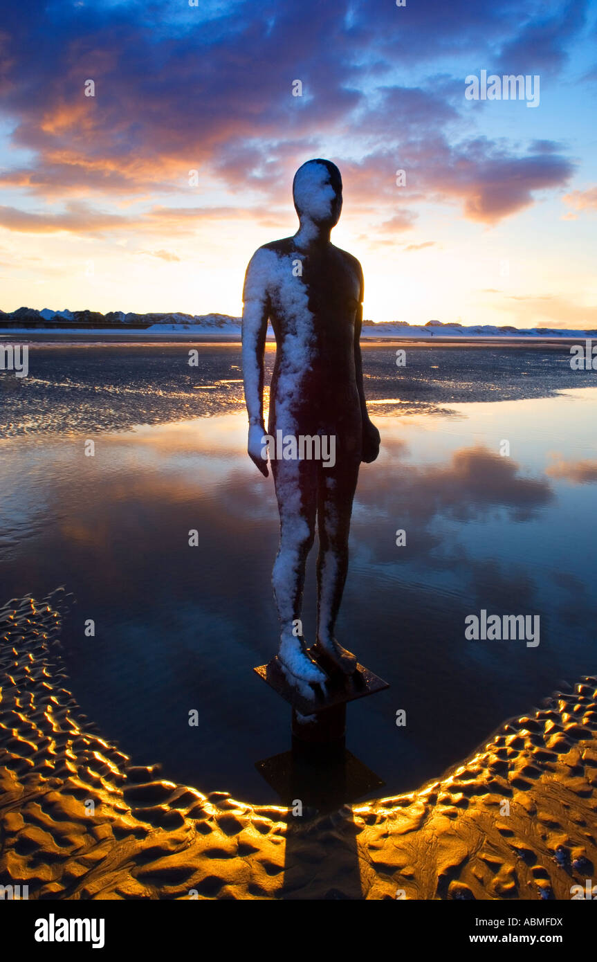Antony Gormley Iron Man Statue auf Crosby Strand, Sefton, Merseyside Uk, bei Sonnenaufgang. Mit vorherigen Nächte Schnee gefroren auf der einen Seite. Stockfoto