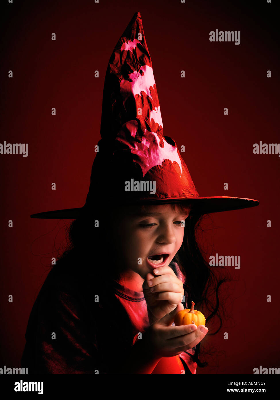 Junge an Halloween Hexen Hut hält kleine Kürbis Stockfoto