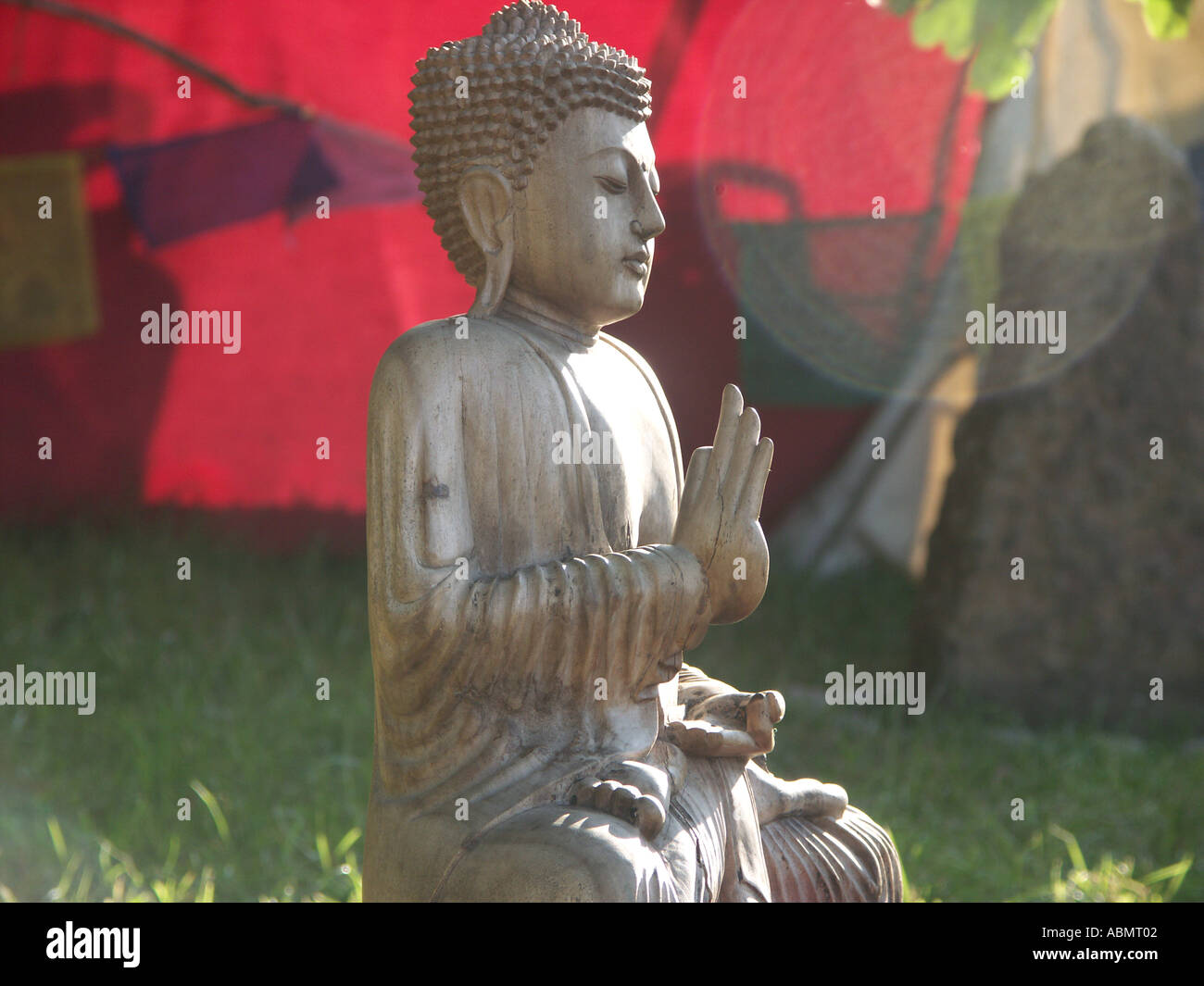 eine hölzerne Buddha sitzt auf Baumstumpf beim Buddhafields Festival uk 2005 Stockfoto