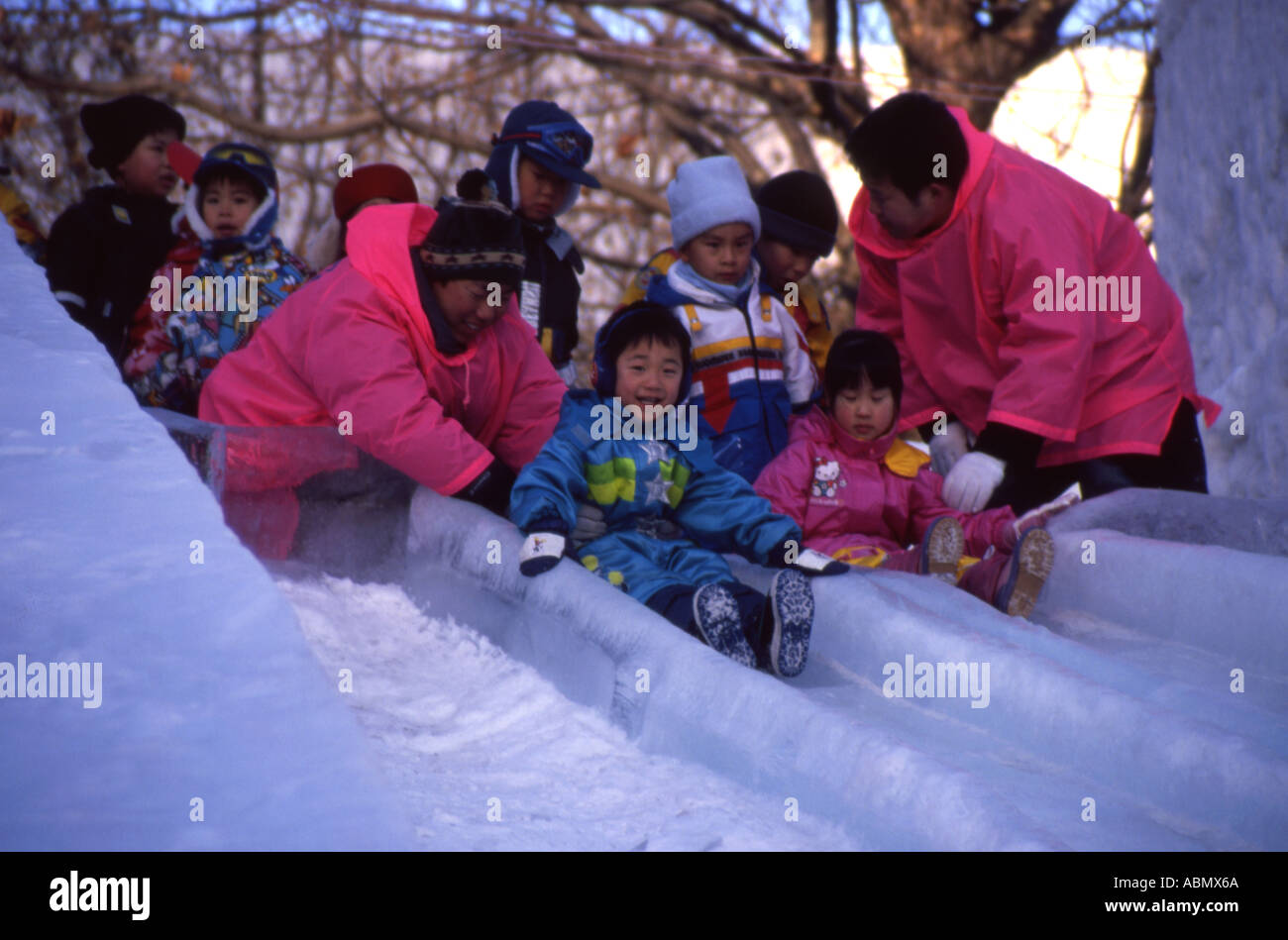 Japanische junge zu Eis Rutsche in Sapporo Snow Festival Hokkaido Japan Rasen Stockfoto