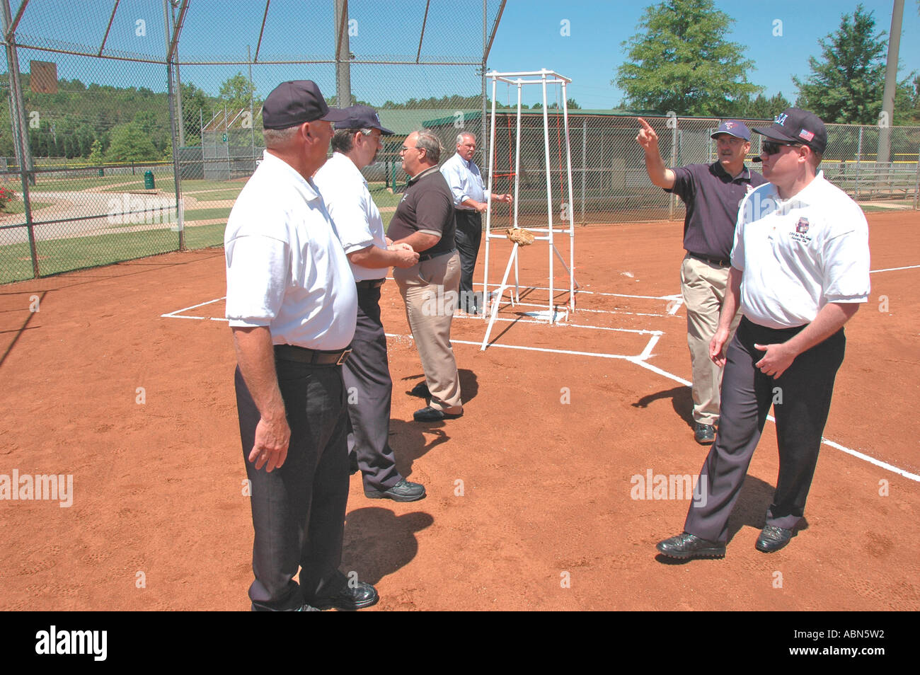 Softball Schiedsrichter für ASA Organisation in den USA und Amerika während der Spiele und in der pregame Kontrolle Fledermäuse und Aufstellungen und Regeln und solche für Team spiele Stockfoto