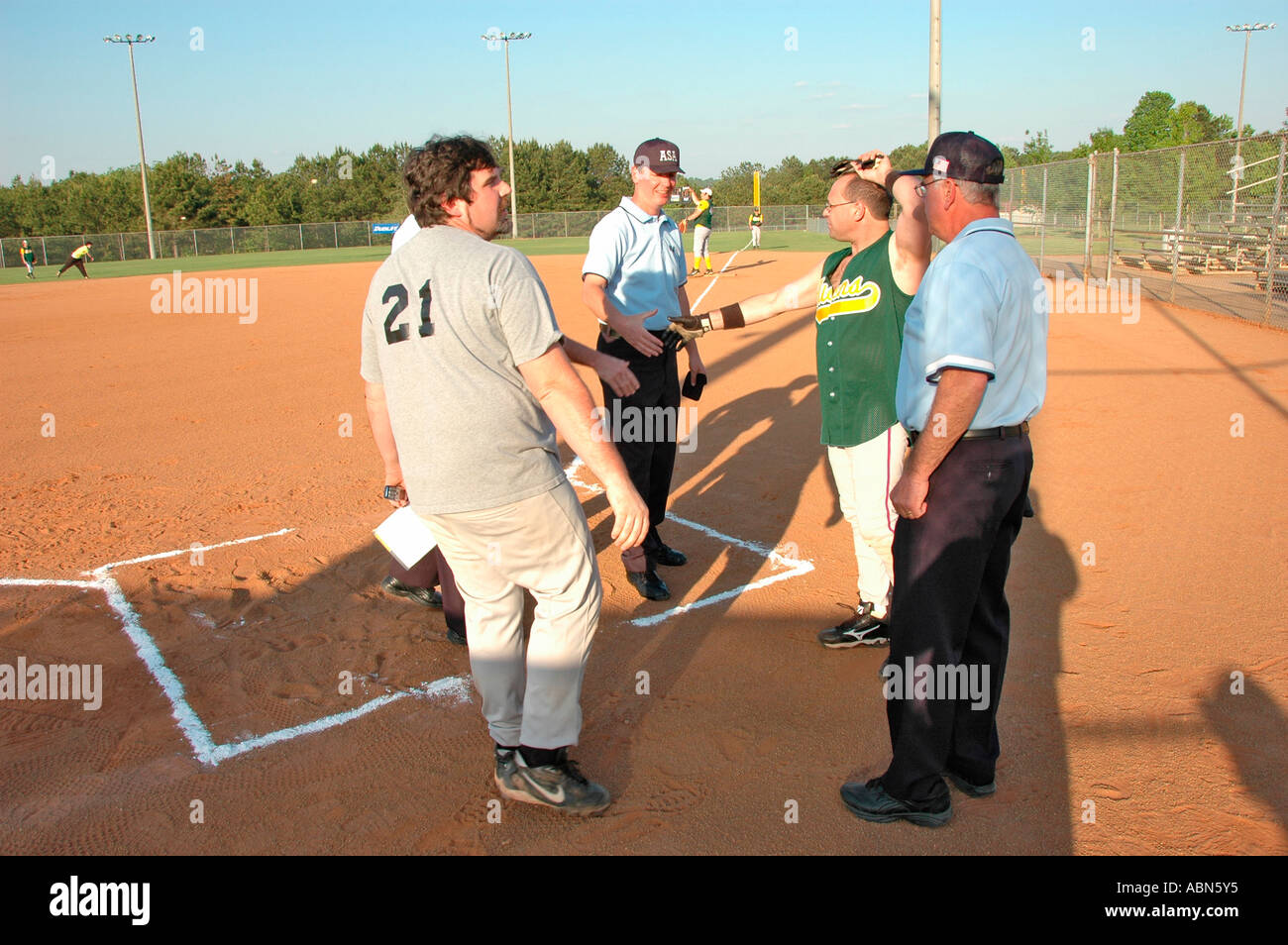 Softball Schiedsrichter für ASA Organisation in den USA und Amerika während der Spiele und in der pregame Kontrolle Fledermäuse und Aufstellungen und Regeln und solche für Team spiele Stockfoto