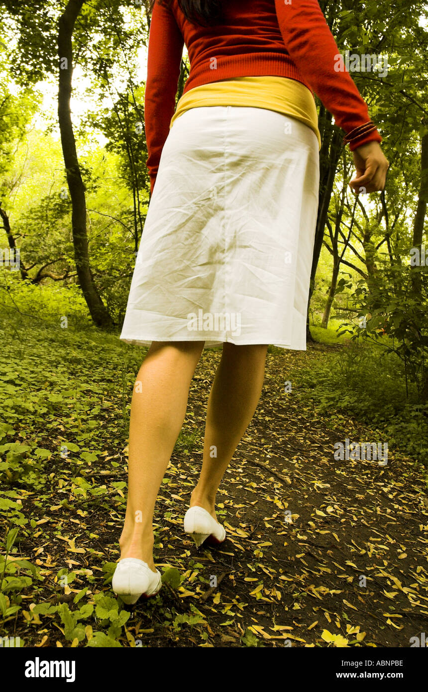 Die Beine einer jungen Frau zu Fuß durch den Wald der Frau Resembes kleine rote Reiten Haube Stockfoto