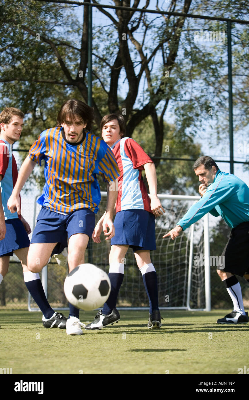 Fußball-Spieler jagt den Ball auf Feld Stockfoto