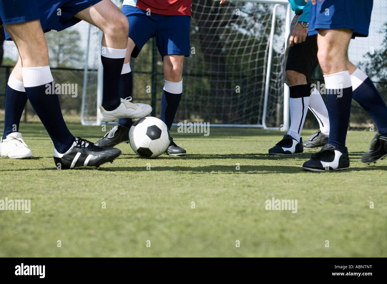 Fußball-Spieler jagt den Ball auf Feld Stockfoto