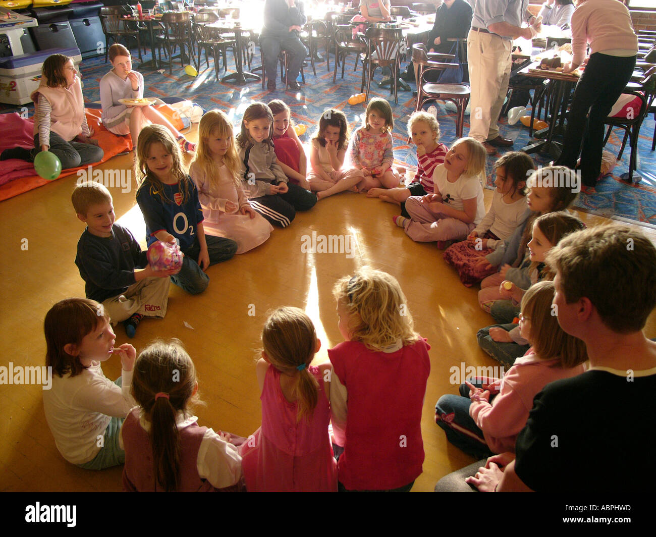 Kinder sitzen im Kreis spielen passieren das Paket Spiel bei kleinen Kindern Party für sechs bis sieben-jährige, UK Stockfoto
