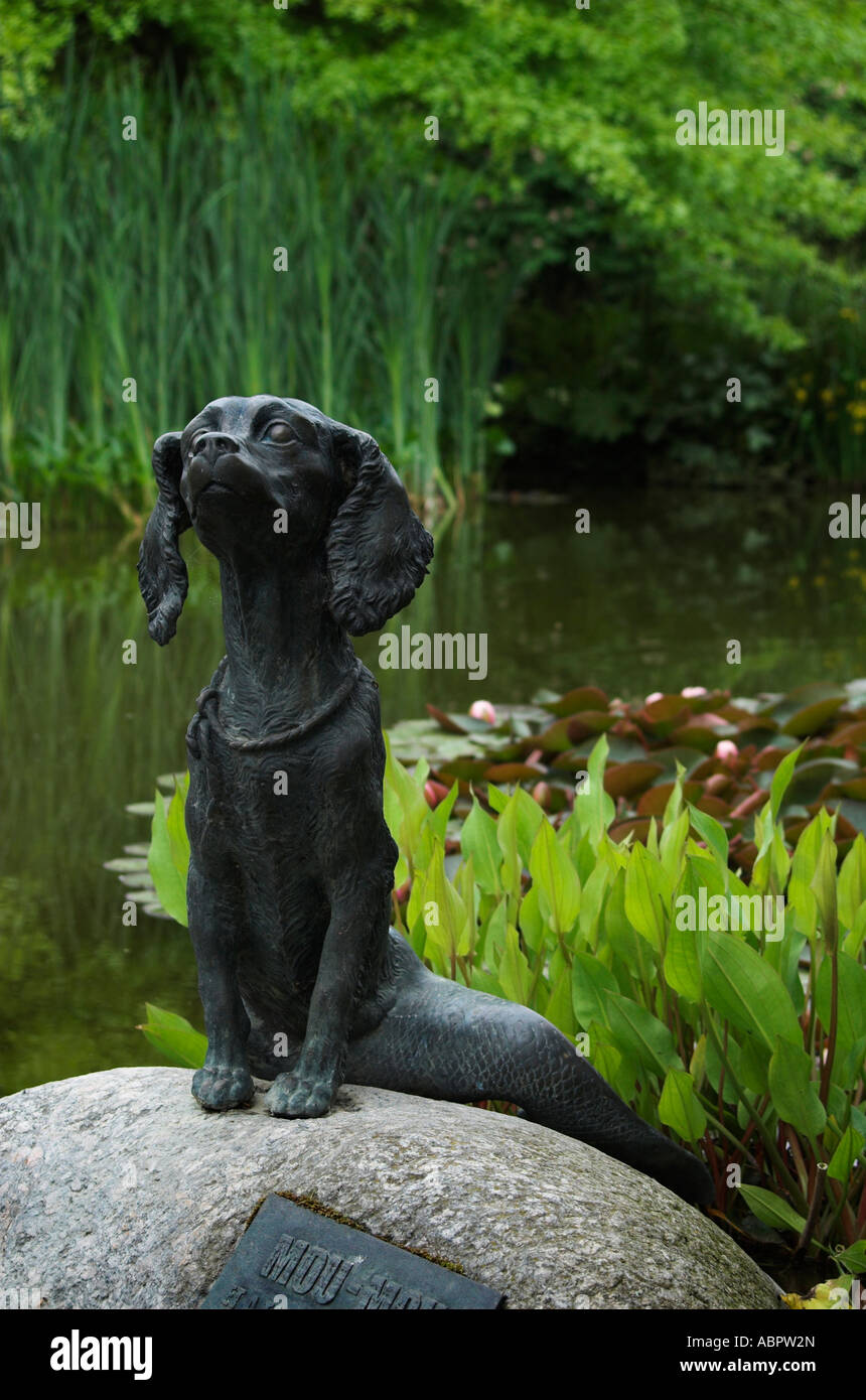 Bronze Figur des fantastischen Tier halb Hund, halb Fisch auf einem Felsen in einem Teich Stockfoto