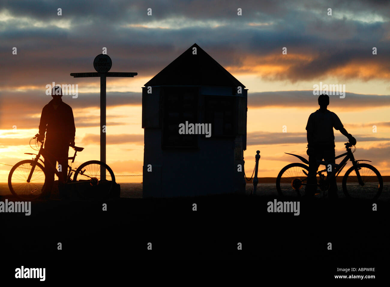 Zwei jungen mit Fahrrädern in der Silhouette bei Sonnenuntergang, John o' Groats Caithness, Highlands, Schottland UK Nordeuropa Stockfoto