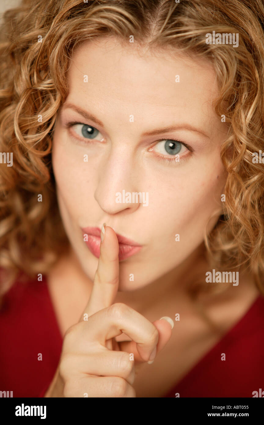 Junge Frau, Blick in die Kamera mit Finger in den Mund Stockfoto