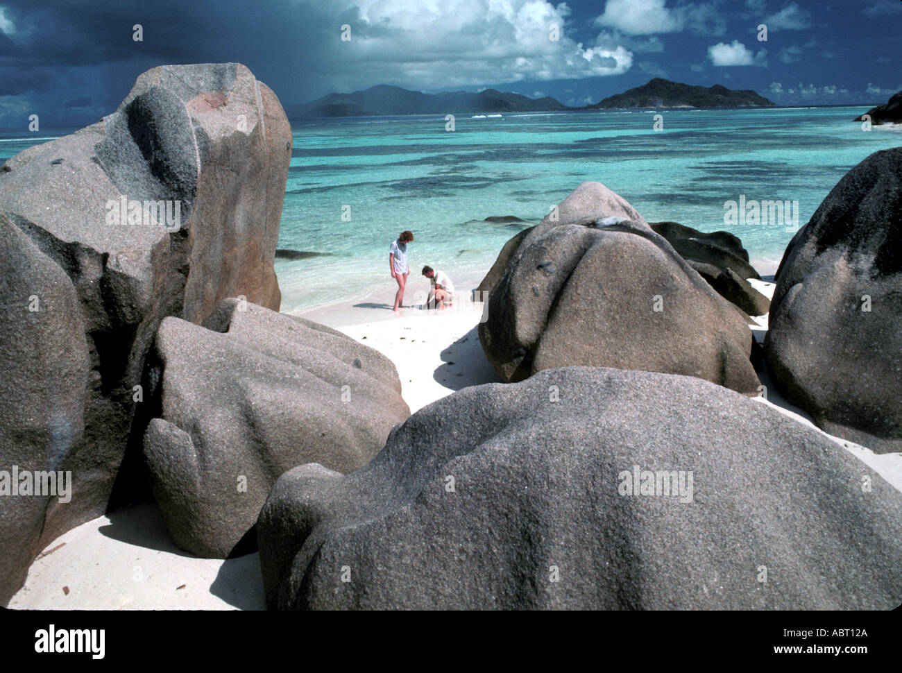 Seychellen Insel La Digue paar am Strand umgeben von Felsen Stockfoto