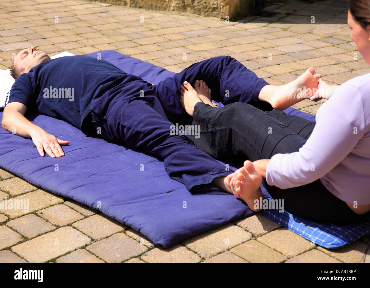 Dehnung der Oberschenkelinnenseite als Teil einer Body-Thai-Massage Stockfoto