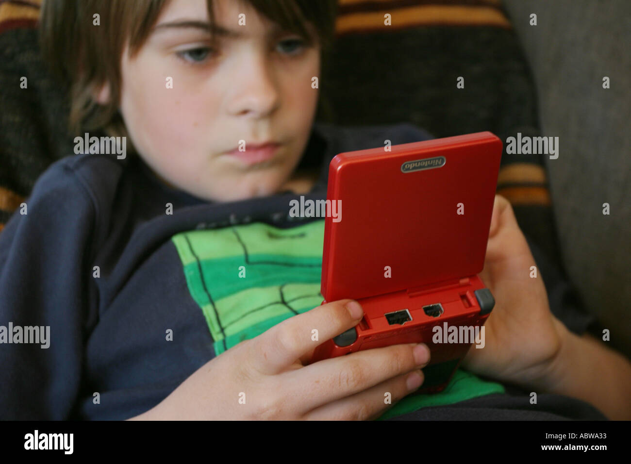 Eine schwedische Junge ein tragbarer Computer Spiel zu Hause. Stockfoto