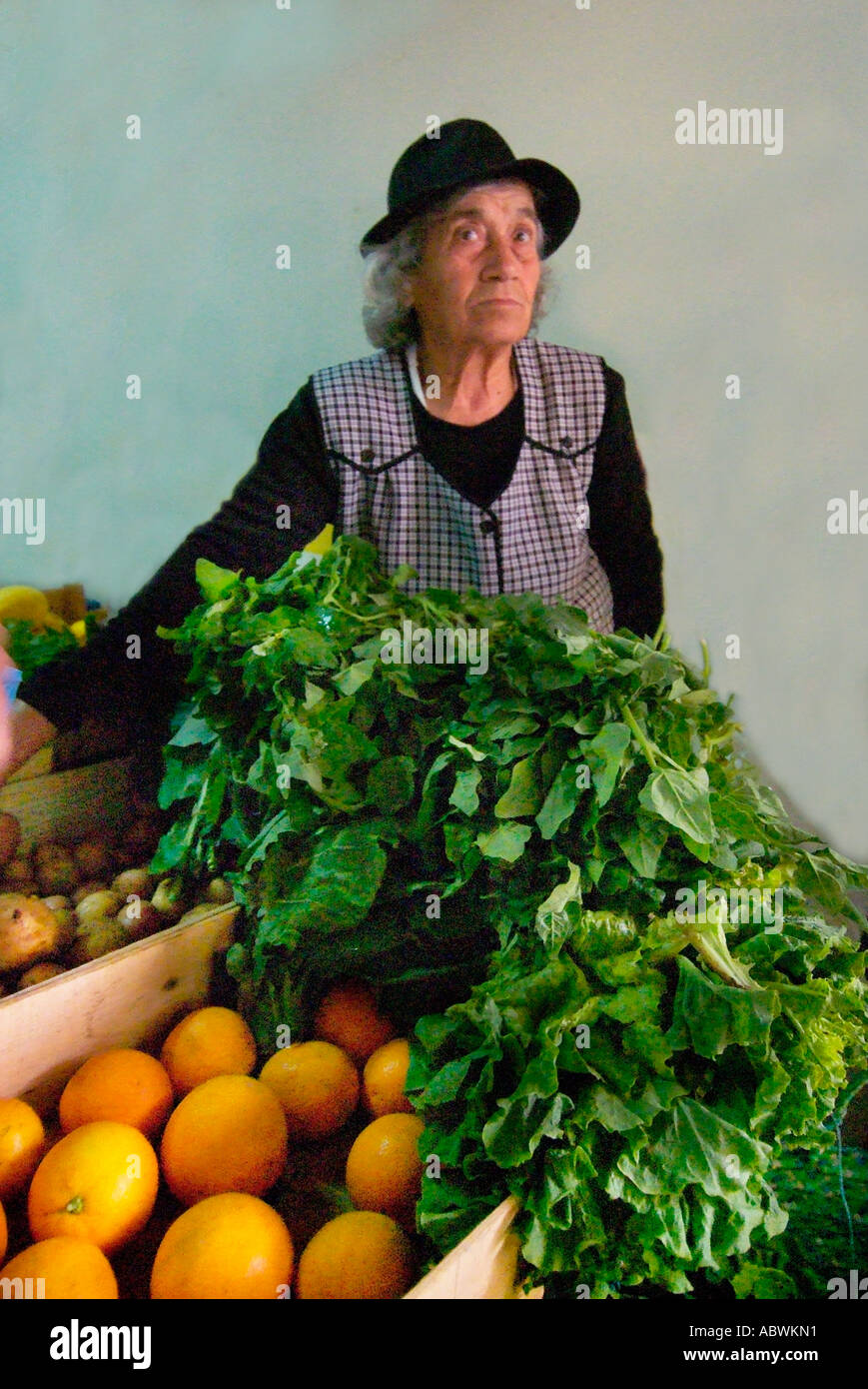 Frisches Obst Gemüse orange Frau stand Halter traditionellen schwarzen Hut Box Case grün Einzelhandel Outdoor-Marktstand Portugal Portug Stockfoto