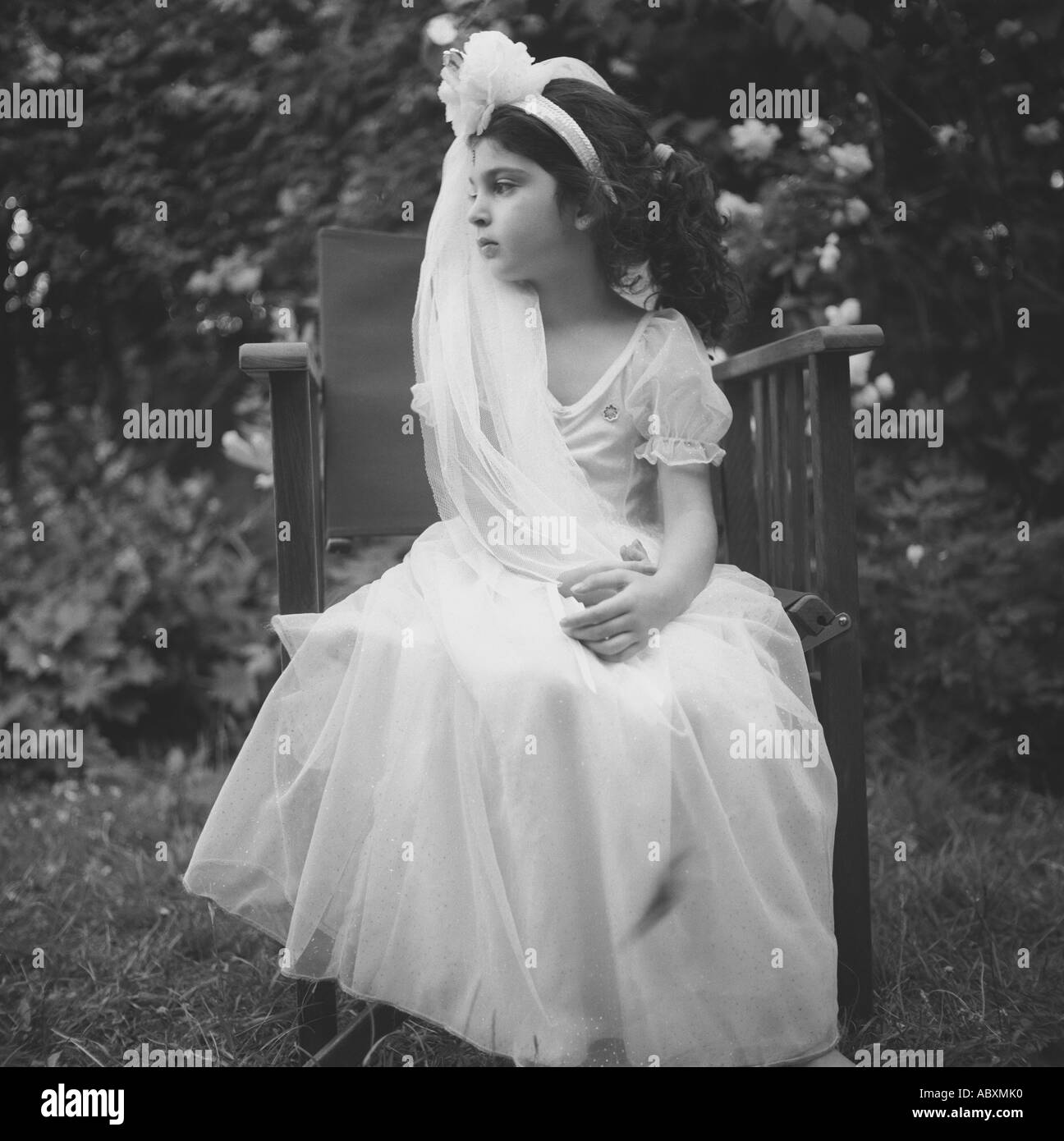 Ein 4 Jahres altes Mädchen, gekleidet in eine Prinzessin Outfit in einem Garten, London, UK. Stockfoto