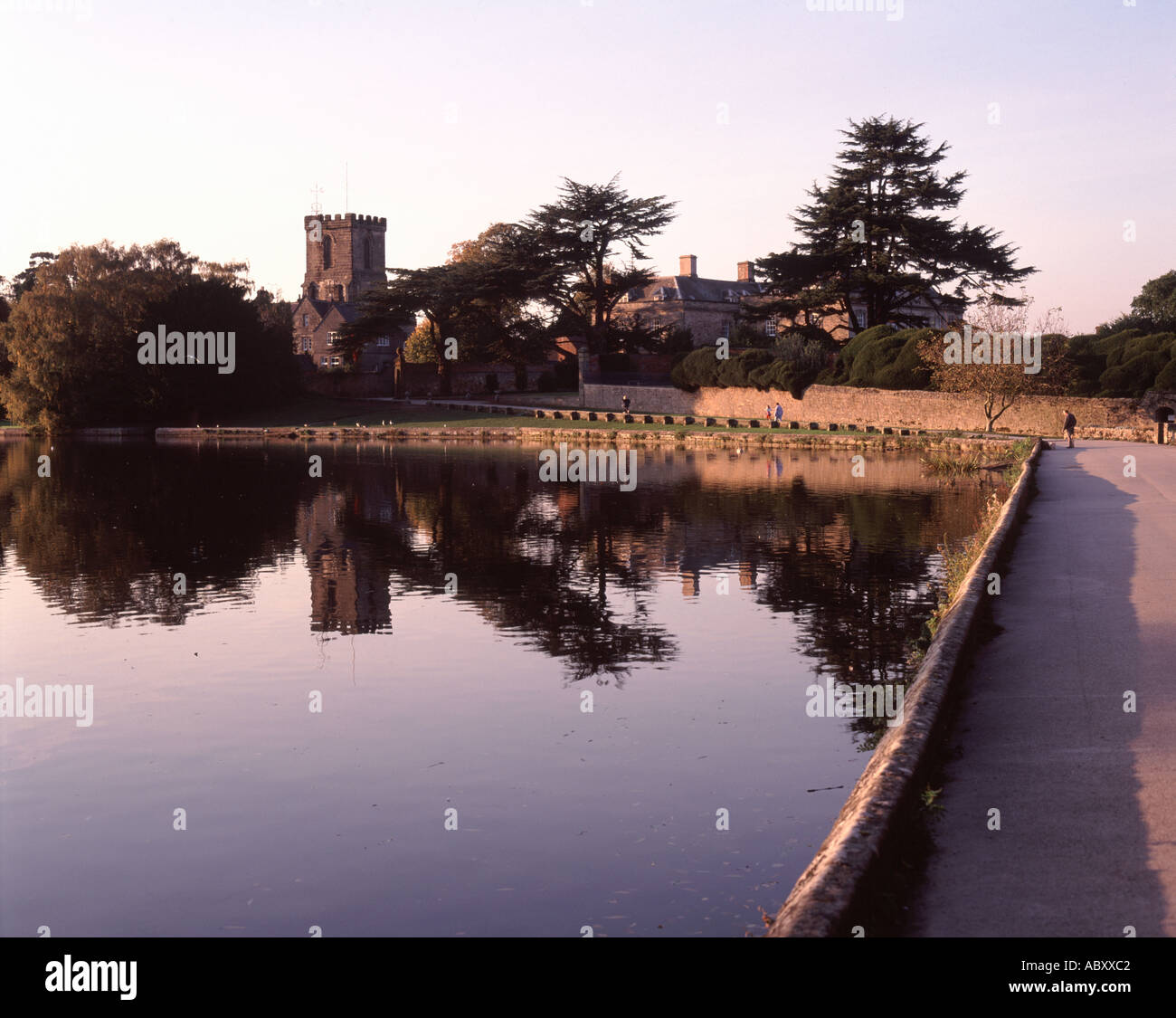 Sommer Abend Blick über Melbourne See nach Melbourne Hall und Kirche in Derbyshire, England Stockfoto