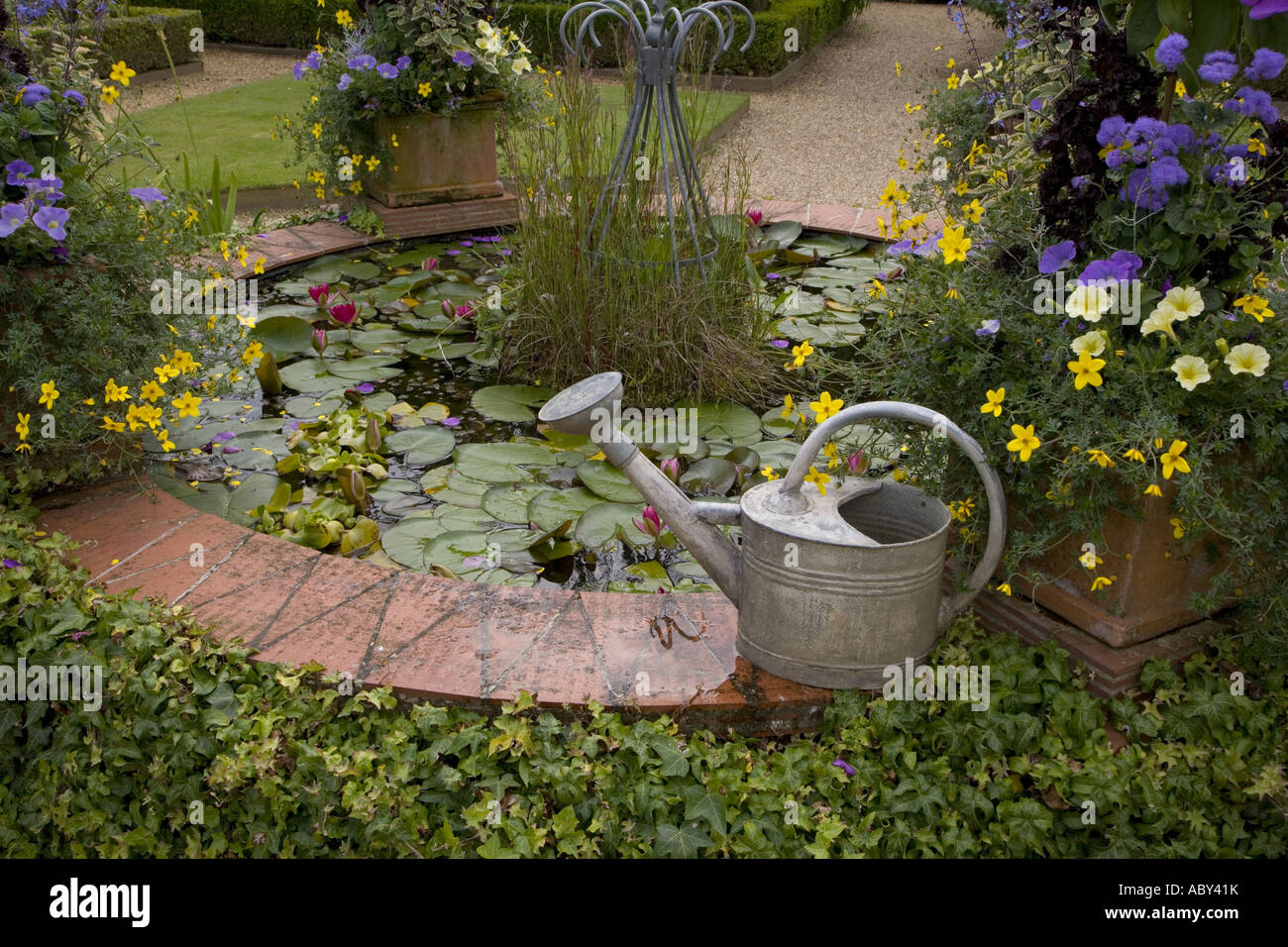 Garten-Teich, Blumen & Gießkanne Stockfoto