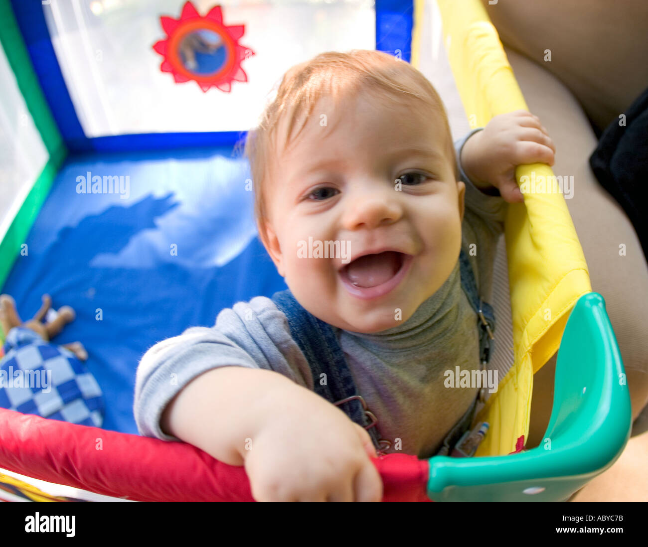 8 Monate altes Baby in Ecke bunte Laufstall stehen Stockfoto