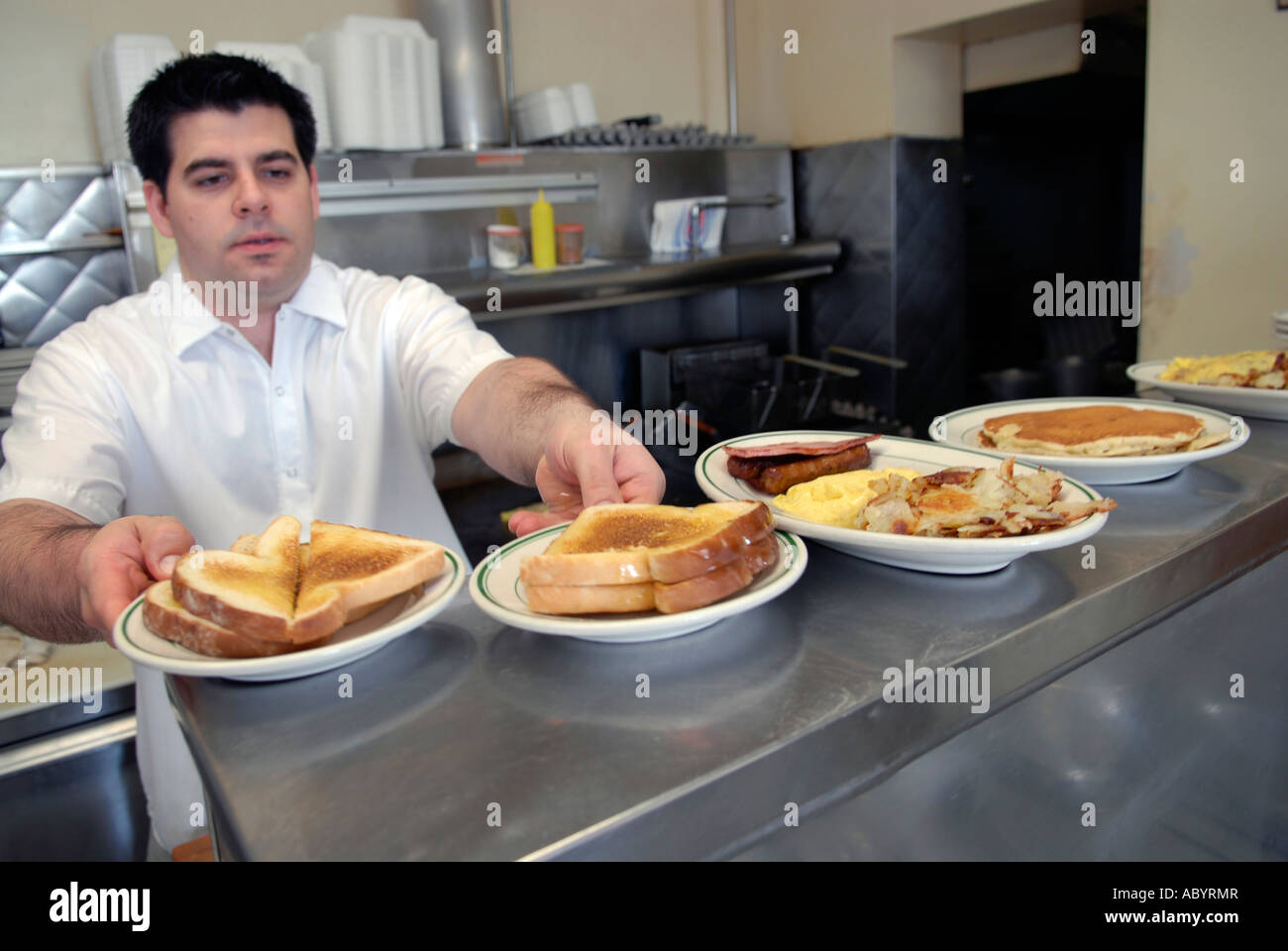 Kurzer Koch bereitet Essen in einem kleinen restaurant Stockfoto