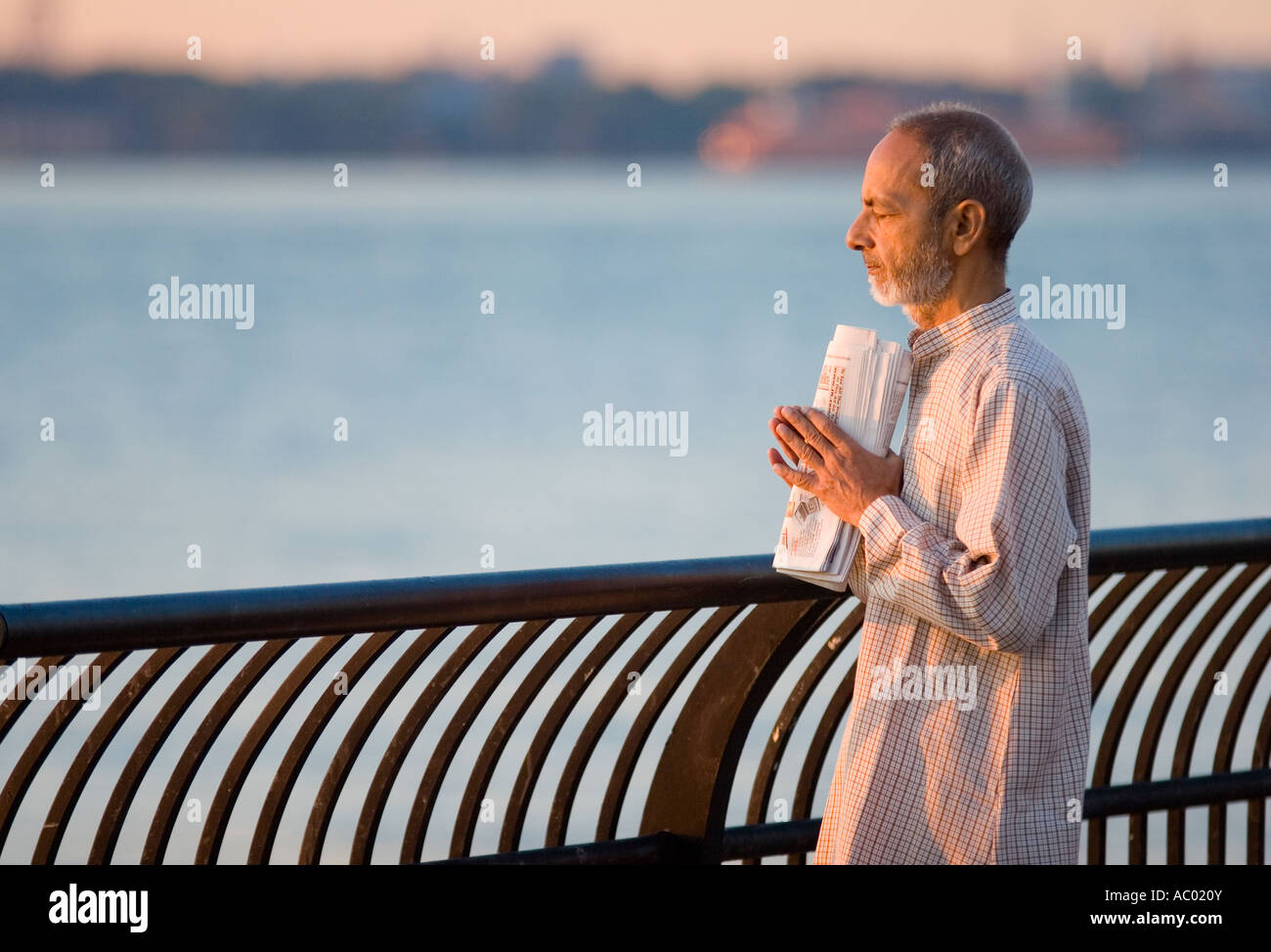 Ein Mann, der betet bei Sonnenaufgang in Jersey City, New Jersey. Stockfoto