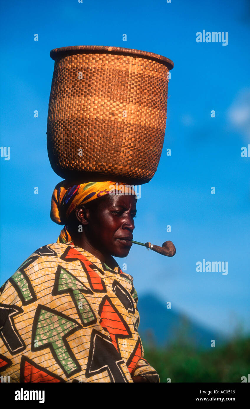 Frau mit Korb und rauchen Pfeife Sabinyo Vulkan im Hintergrund demokratische Republik Kongo Stockfoto