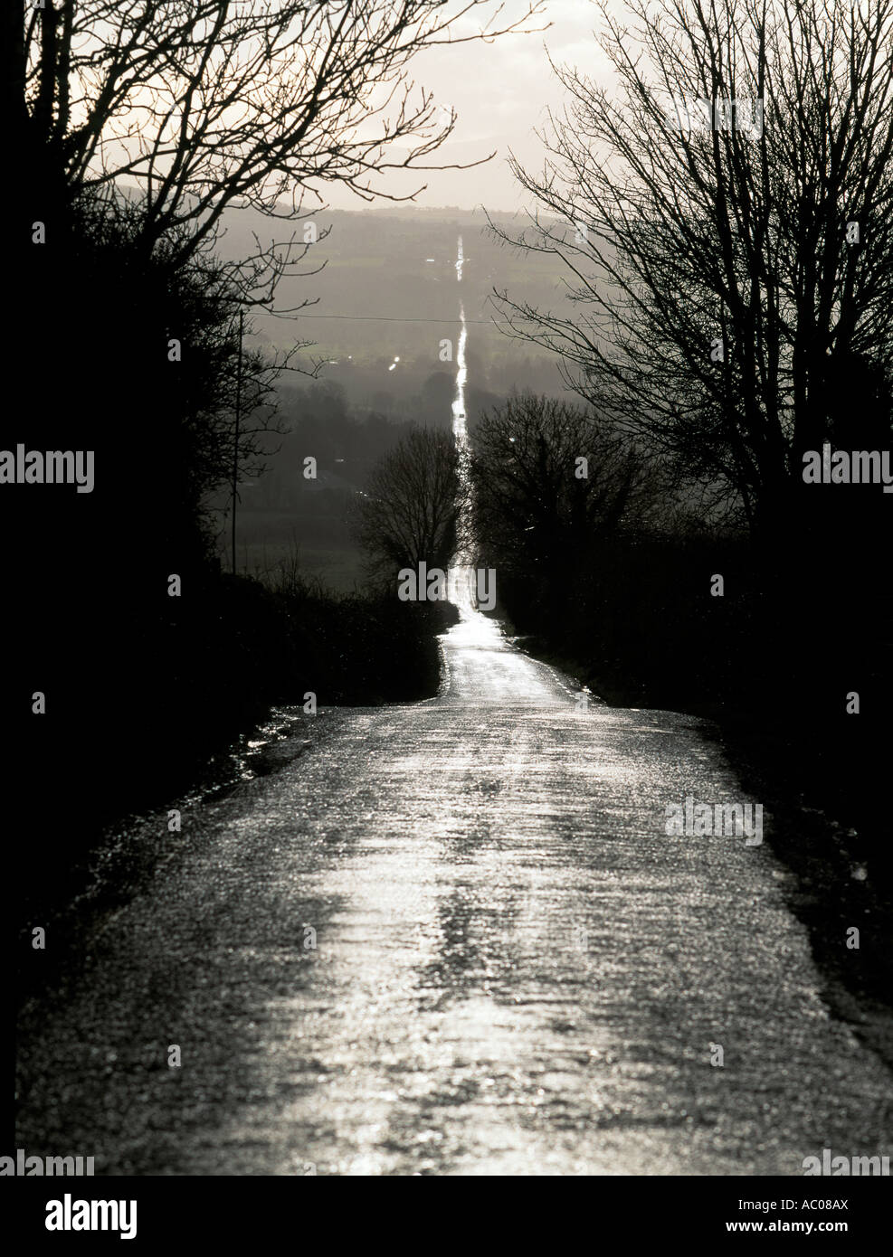 lange schmale geradeaus bergab und bergauf in der Ferne, Regen durchnässt alte Heerstraße in Irland Stockfoto