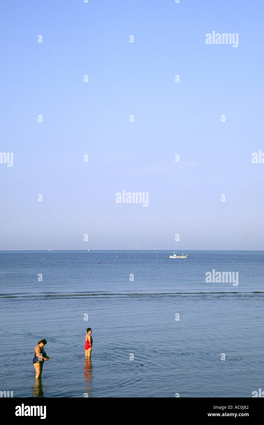 Zwei Frauen stehen im Meer in Grado, Italien. Stockfoto