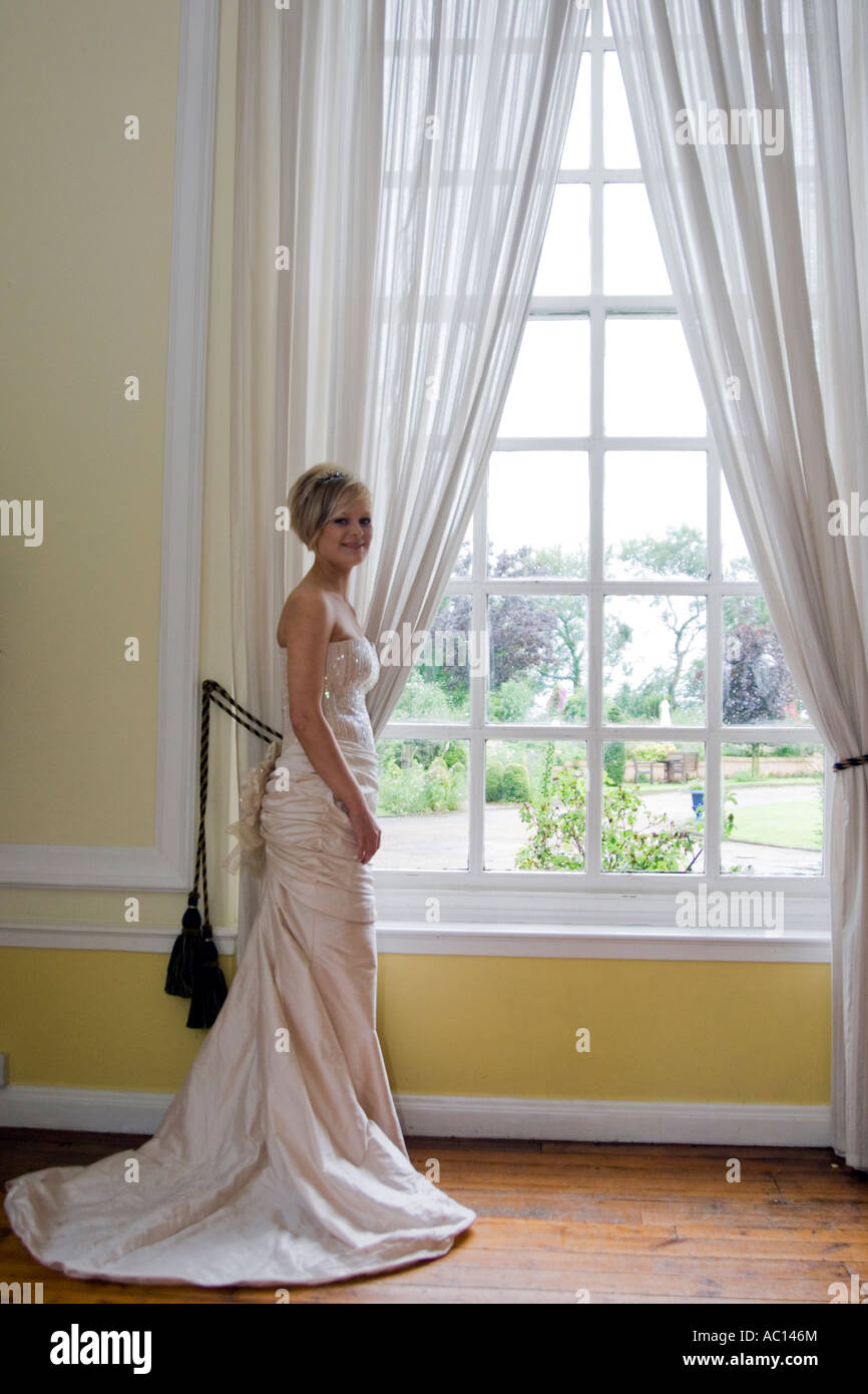 attraktive Braut durch ein Fenster Stockfoto