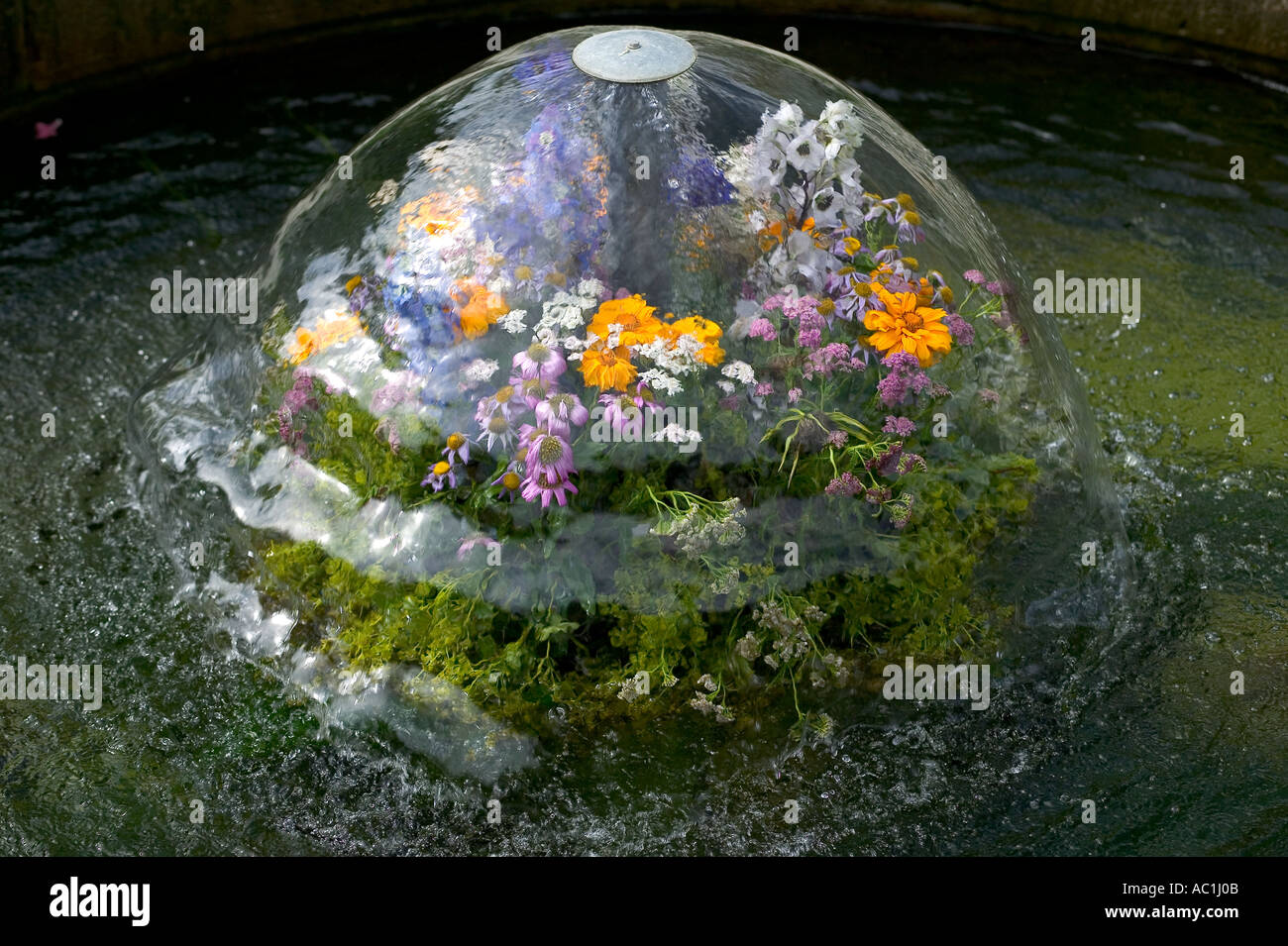 BLUMENGESCHMÜCKTEN BRUNNEN IN DEN GÄRTEN VON SCHLOSS NYMPHENBURG MÜNCHEN BAYERN DEUTSCHLAND Stockfoto