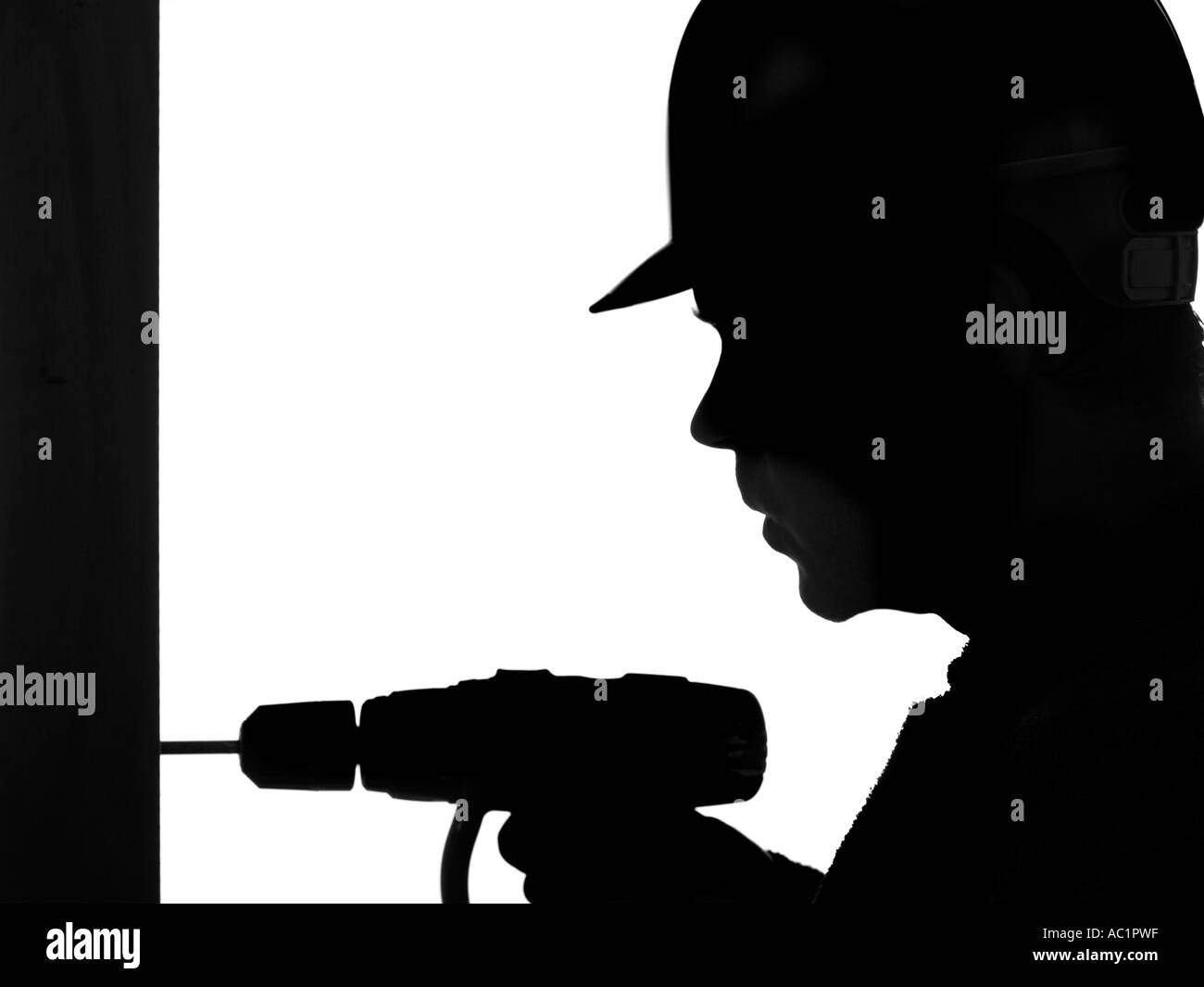 Silhouette des Generators in Sicherheit Schutzhelm mit Handbohrer Stockfoto