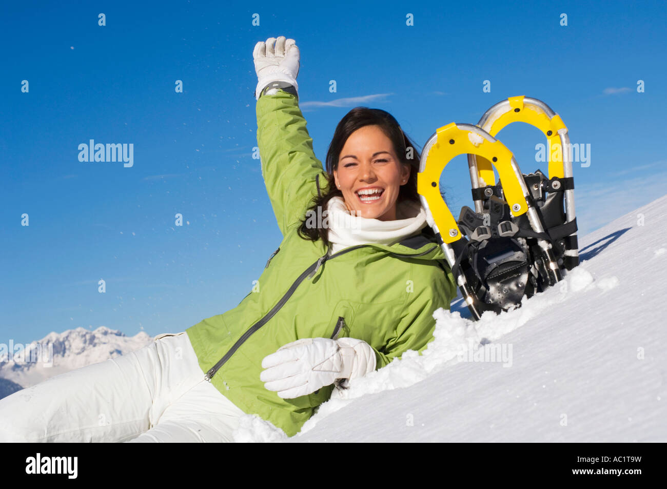 Frau mit Schneeschuhen, Arm heben Stockfoto