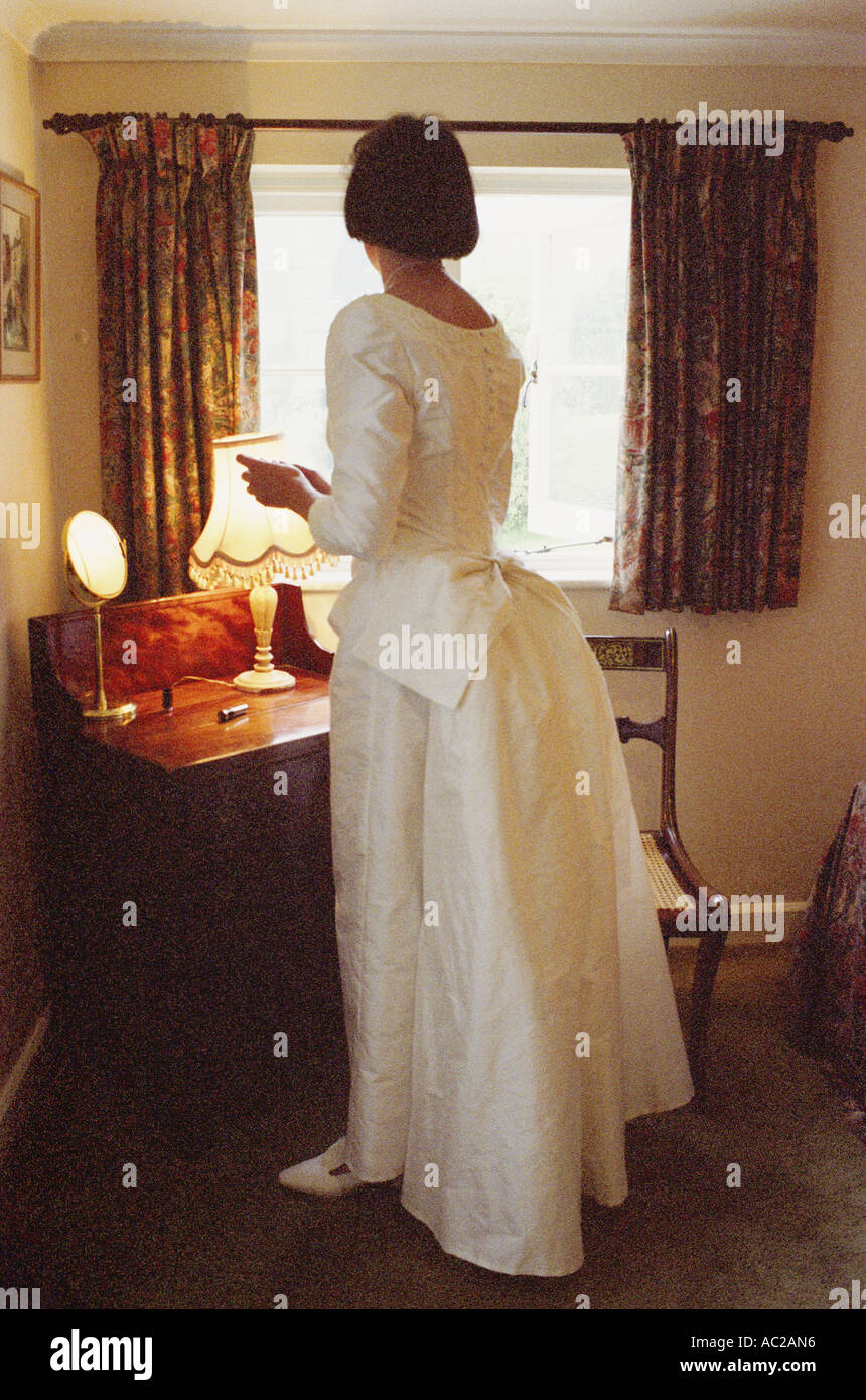 Braut, die sich vor ihrer Hochzeit in ihrem Schlafzimmer in den 1990er Jahren, Devon, England, Großbritannien, Make-up Stockfoto