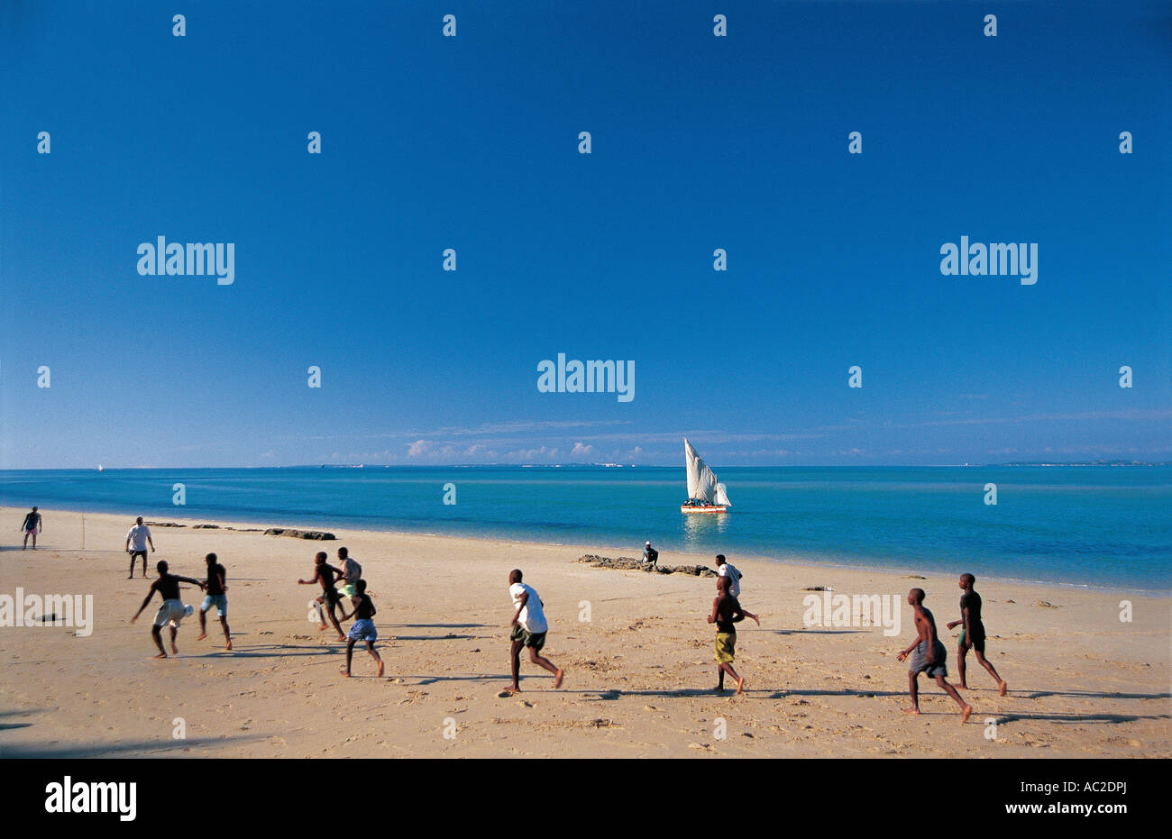 Jugendliche spielen Beach-Soccer bei Ebbe Vilankulo zentralen Mosambik ein Segelboot in der Nähe der Küste ist Stockfoto