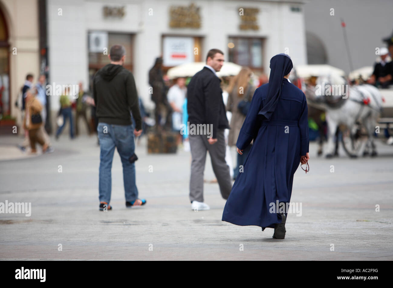 Nonne in dunkel blau Gewohnheit zu Fuß entfernt von der Kamera hielt  Rosenkranz über Rynek Glowny Stadt quadratische Krakau Stockfotografie -  Alamy