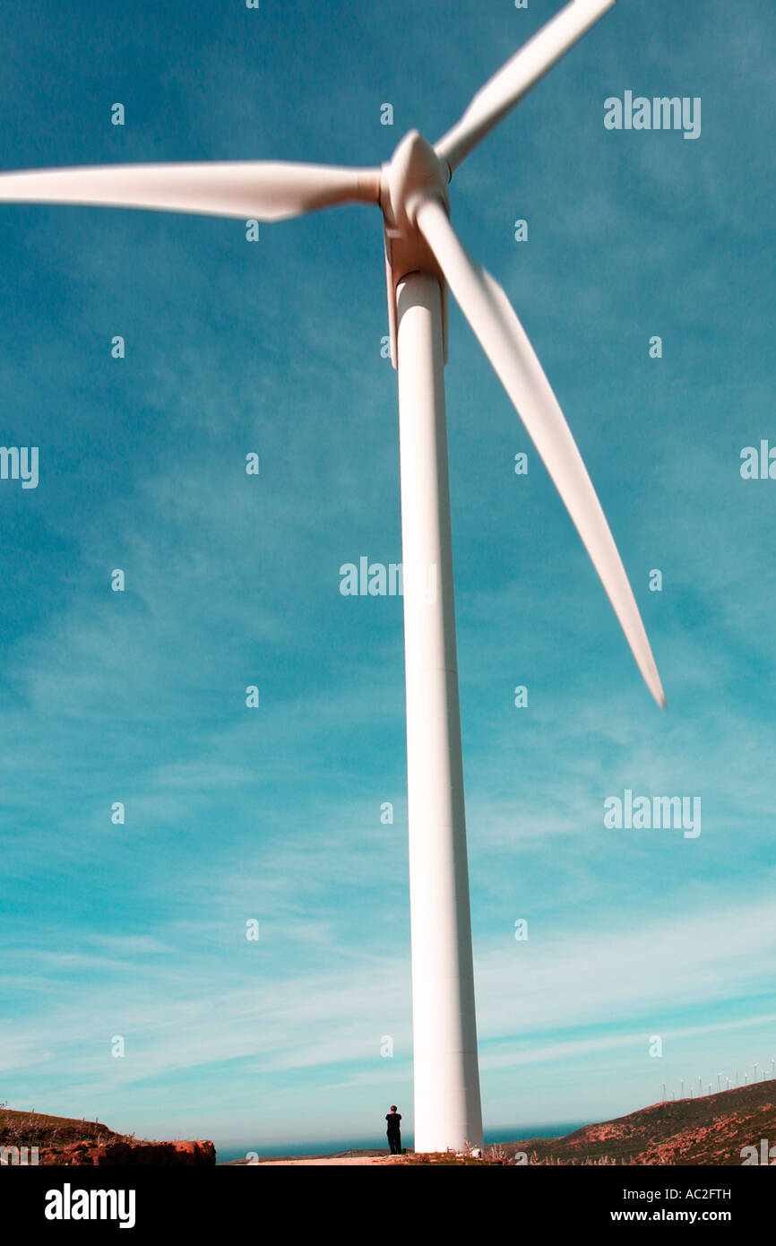Kleine Figur eines Mannes stehend auf Basis der riesige Windmühle in der Nähe von Tarifa Cadiz Provinz Andalusien Spanien Stockfoto