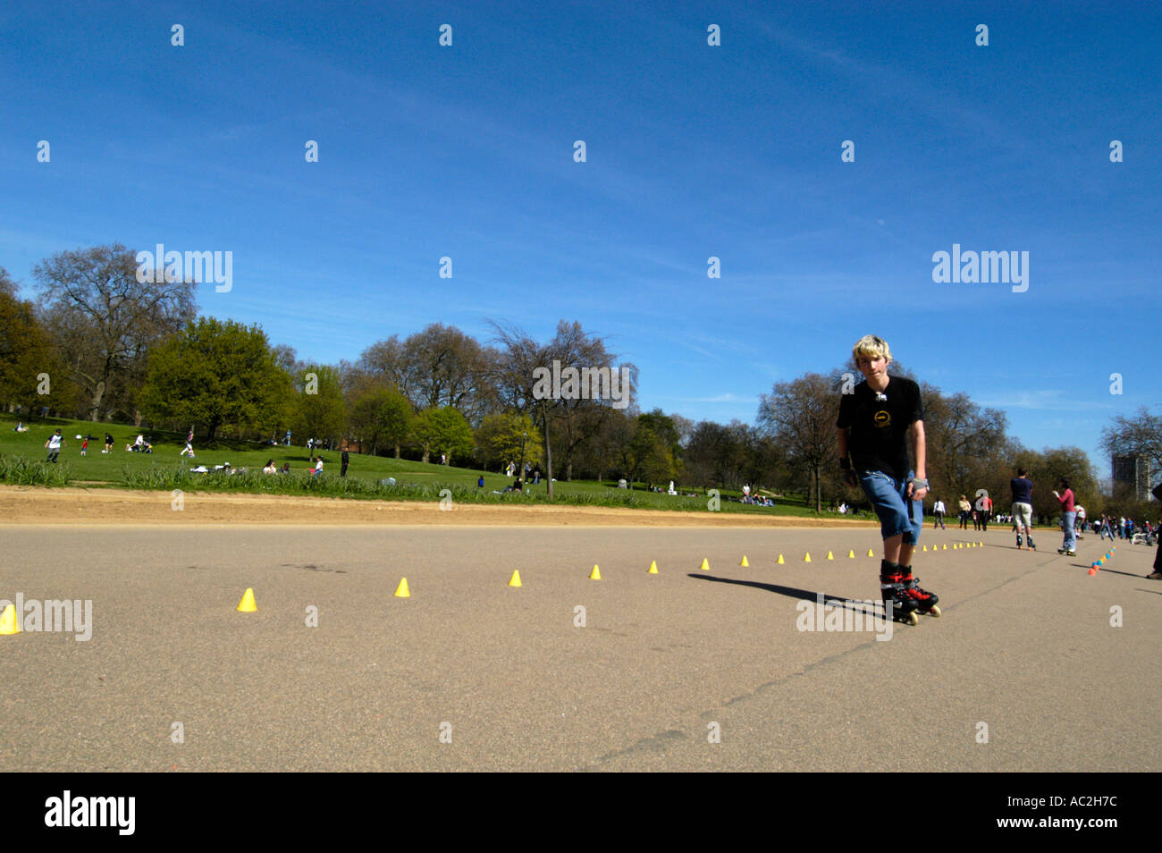 Junger Teenager Inlineskating durch Slalom Kegel im Hyde Park London England UK Stockfoto