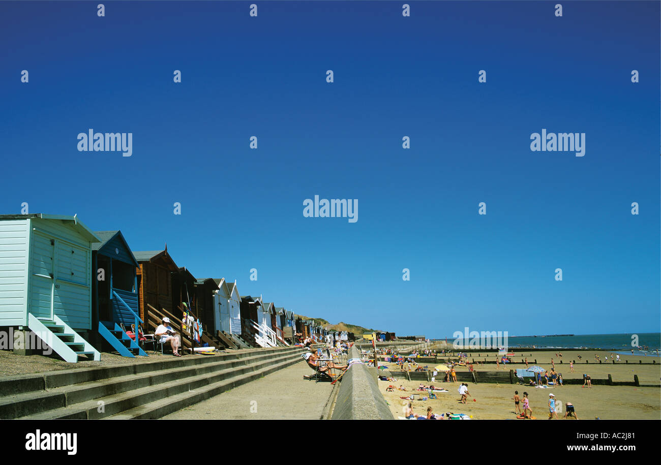 Bunte Strandhäuschen hinter der Promenade entlang des breiten Sandstrandes an Frinton Blick nach Osten in Richtung Walton Stockfoto