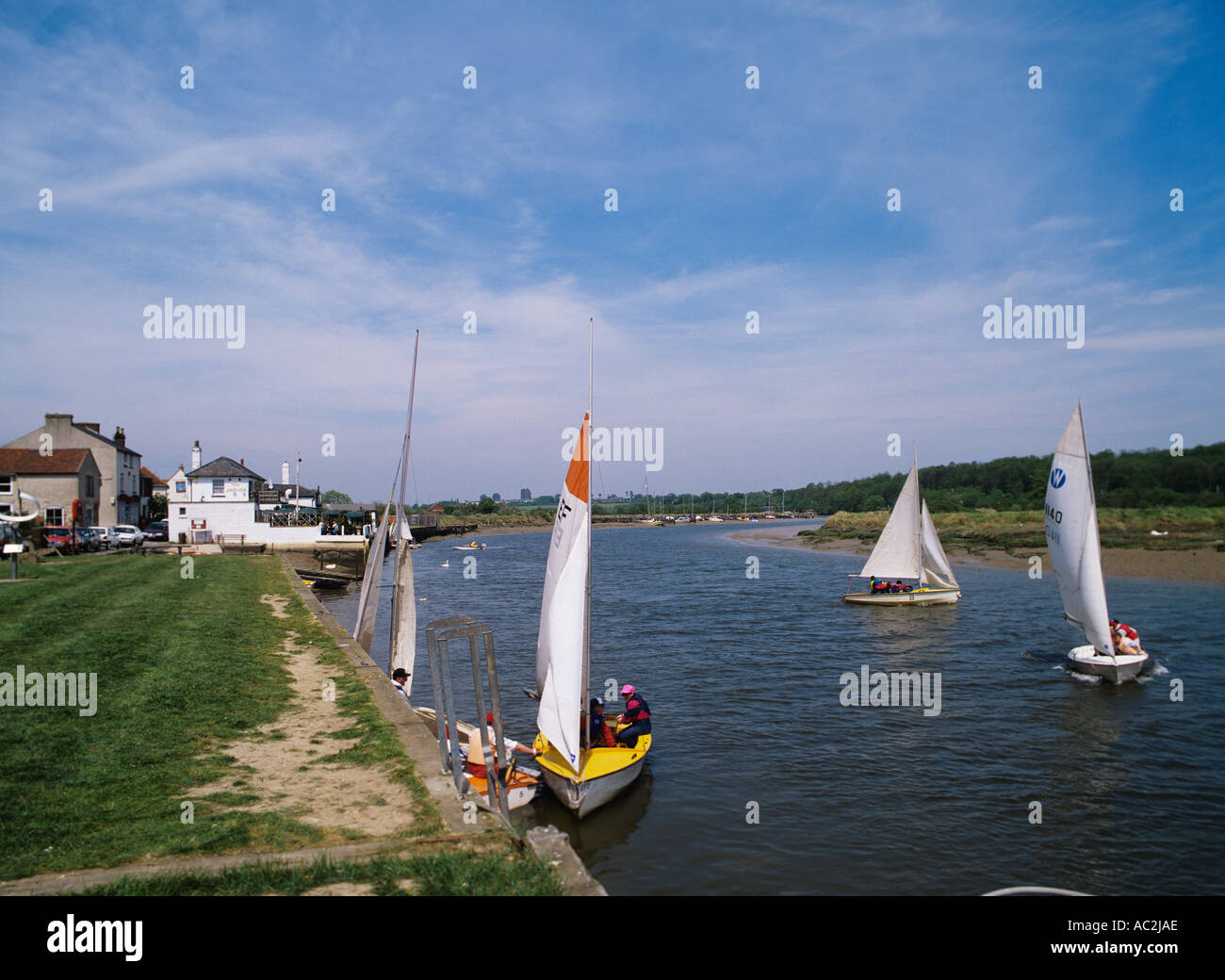 kleine Segelboote auf dem Fluss Colne im Rowhedge unterhalb von Coclhester The Anchor Pub am Flussufer Stockfoto