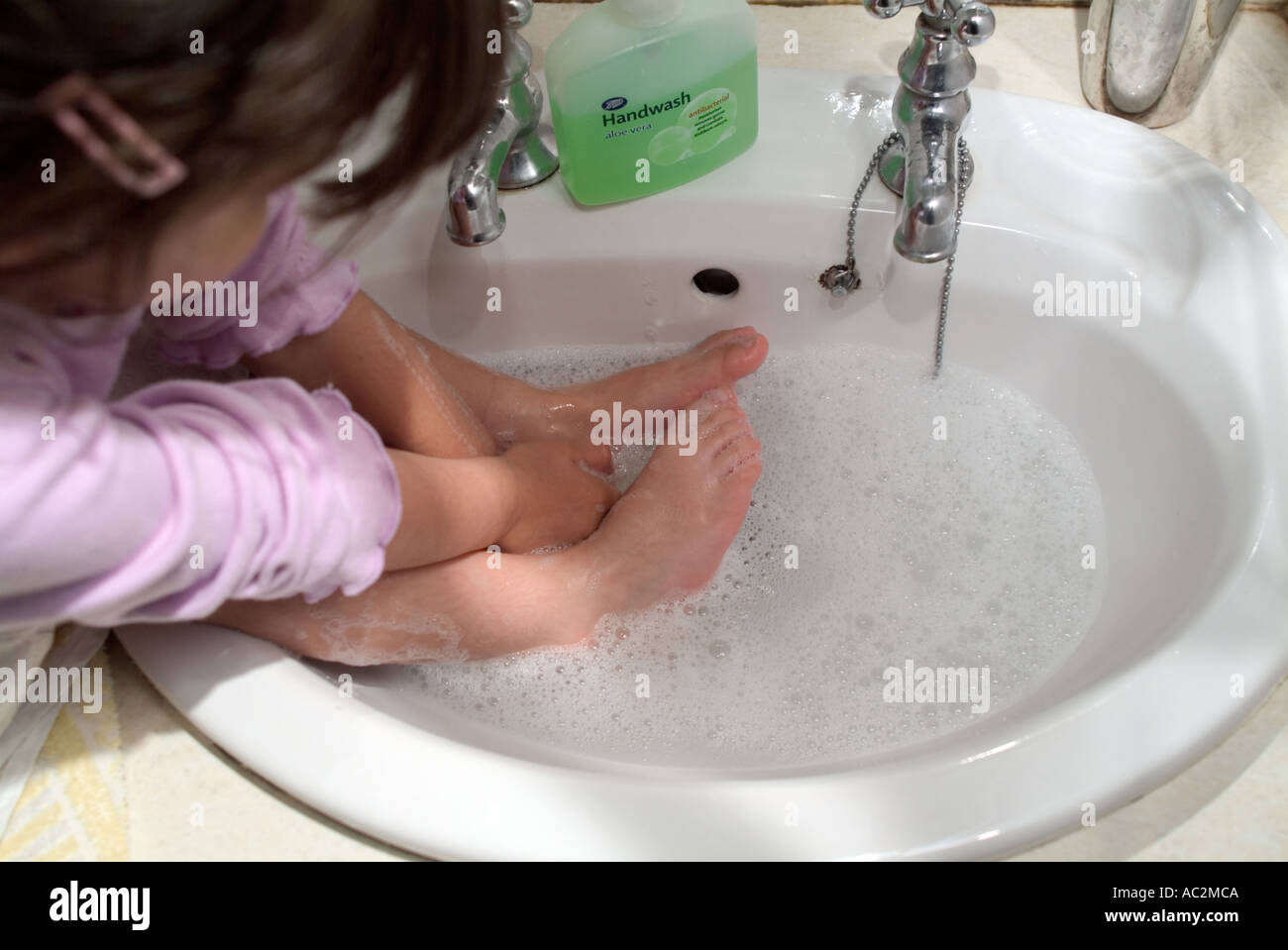 Kind, waschen Sie ihre Füße im Becken Stockfoto