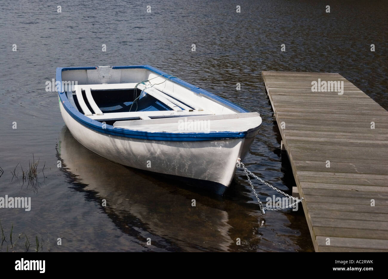 Ein kleines Freizeit Boot an einem Steg auf einem schottischen Loch in der Nähe von Loch Lomond gefesselt Stockfoto