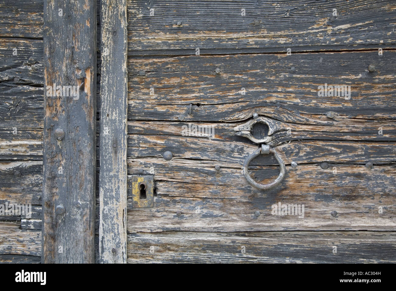 Detail mit Schloss und Griff verwitterte alte paintless Holztür in Rémuzat, Drôme, Frankreich Stockfoto