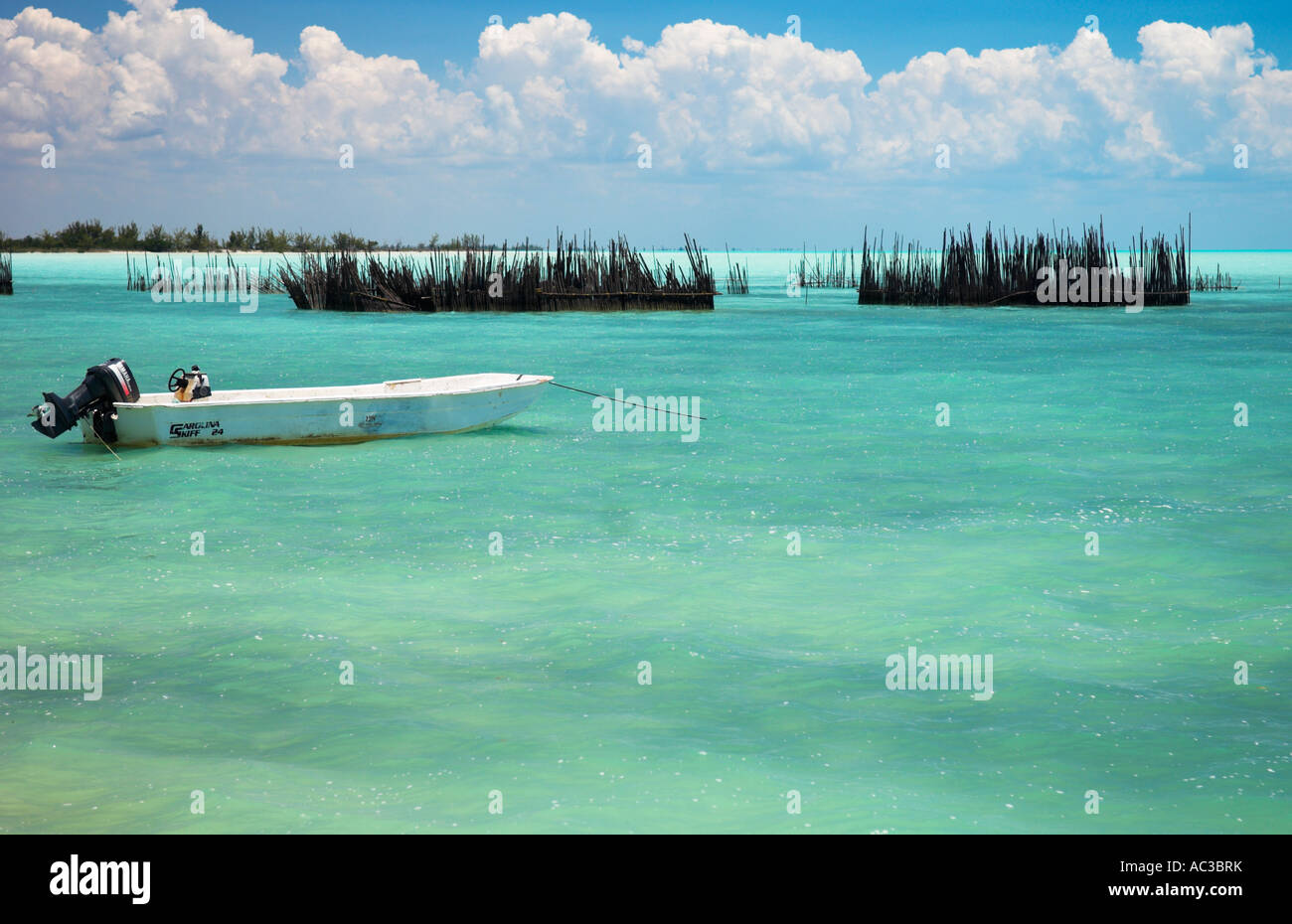 Eine kleine Freude Angeln Boot und Fische Stifte auf ruhigen türkis blaue Meer Nord Seite Andros Island Bahamas Stockfoto