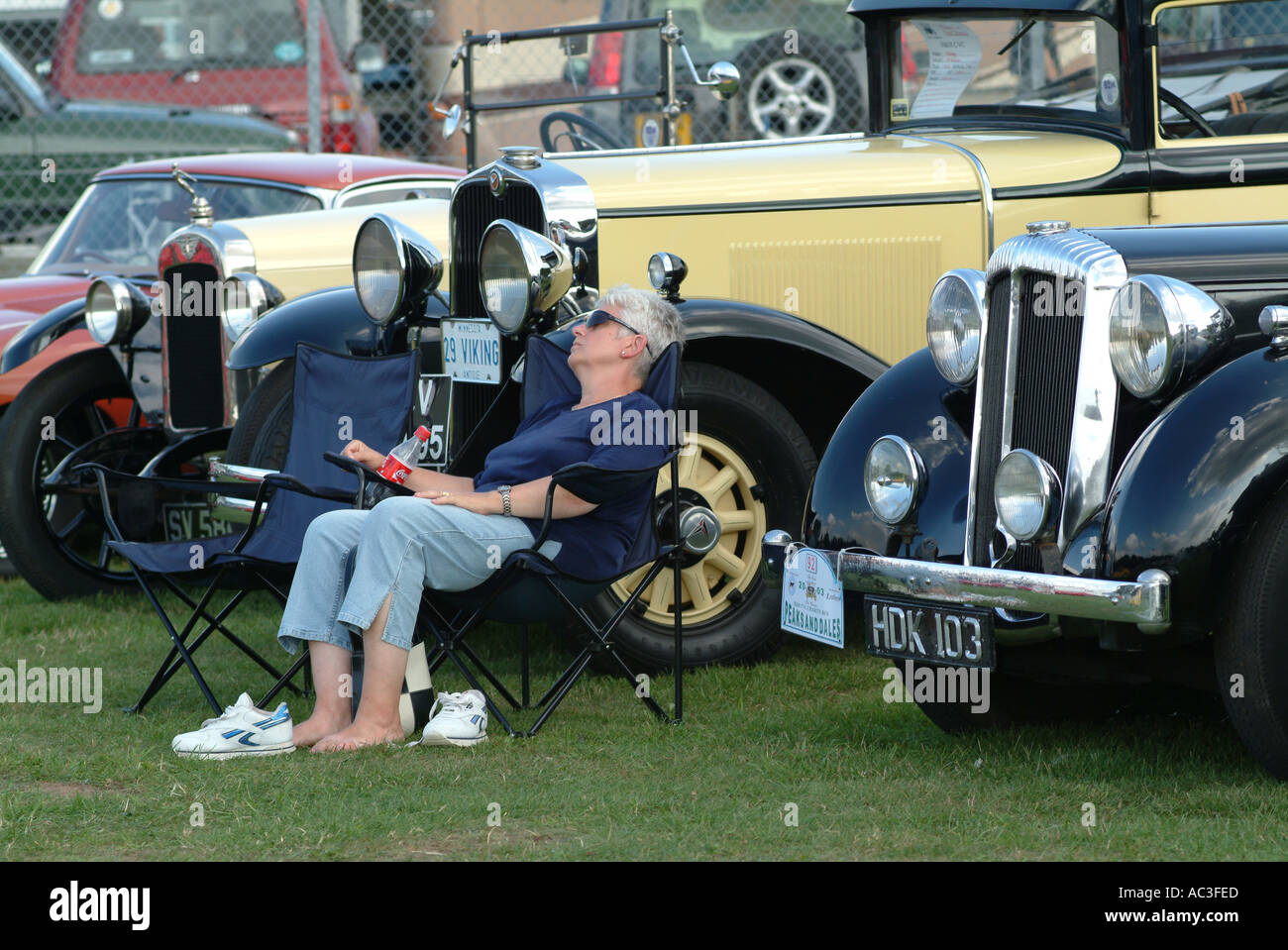Dame mit ein Nickerchen vor Oldtimer in Oulton Park Motor Racing Circuit Cheshire England Vereinigtes Königreich UK Stockfoto