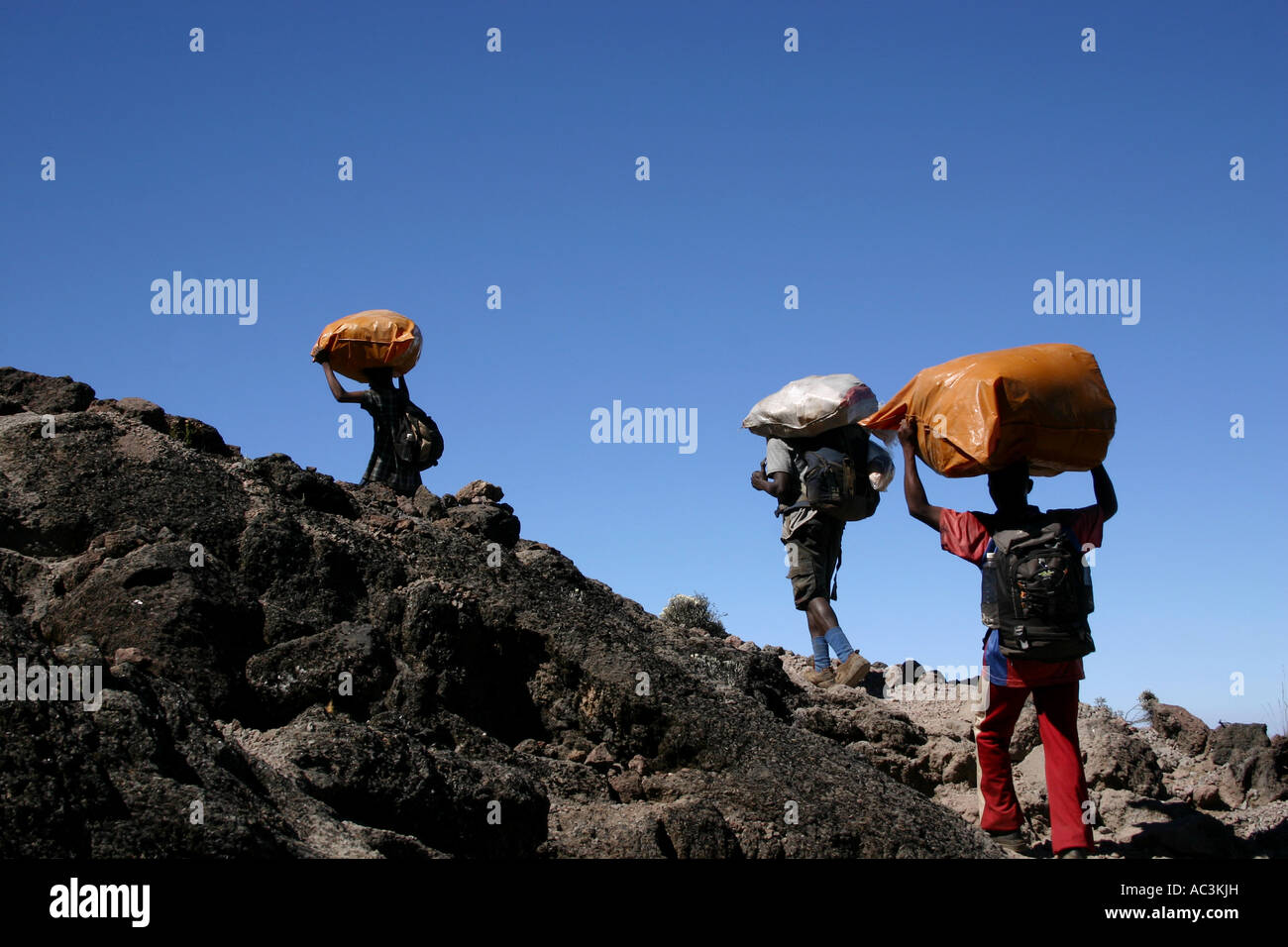 Drei Träger tragen schwerer Lasten, Klettern auf die Machame-Route über Barranco Wall Mount Kilimanjaro, Tansania Stockfoto