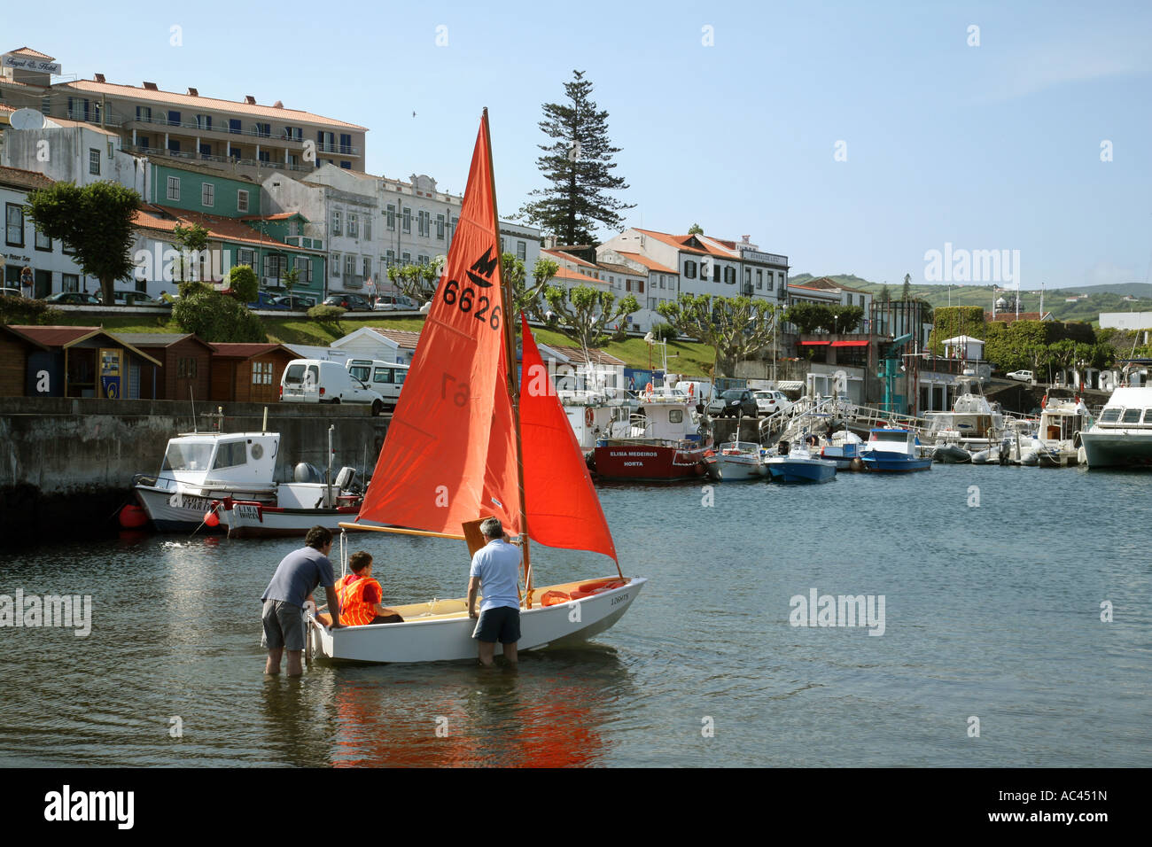 Ein kleiner Junge, Segeln auf einer Yacht Segelboot, der Horta Marina, Faial, Azoren Stockfoto