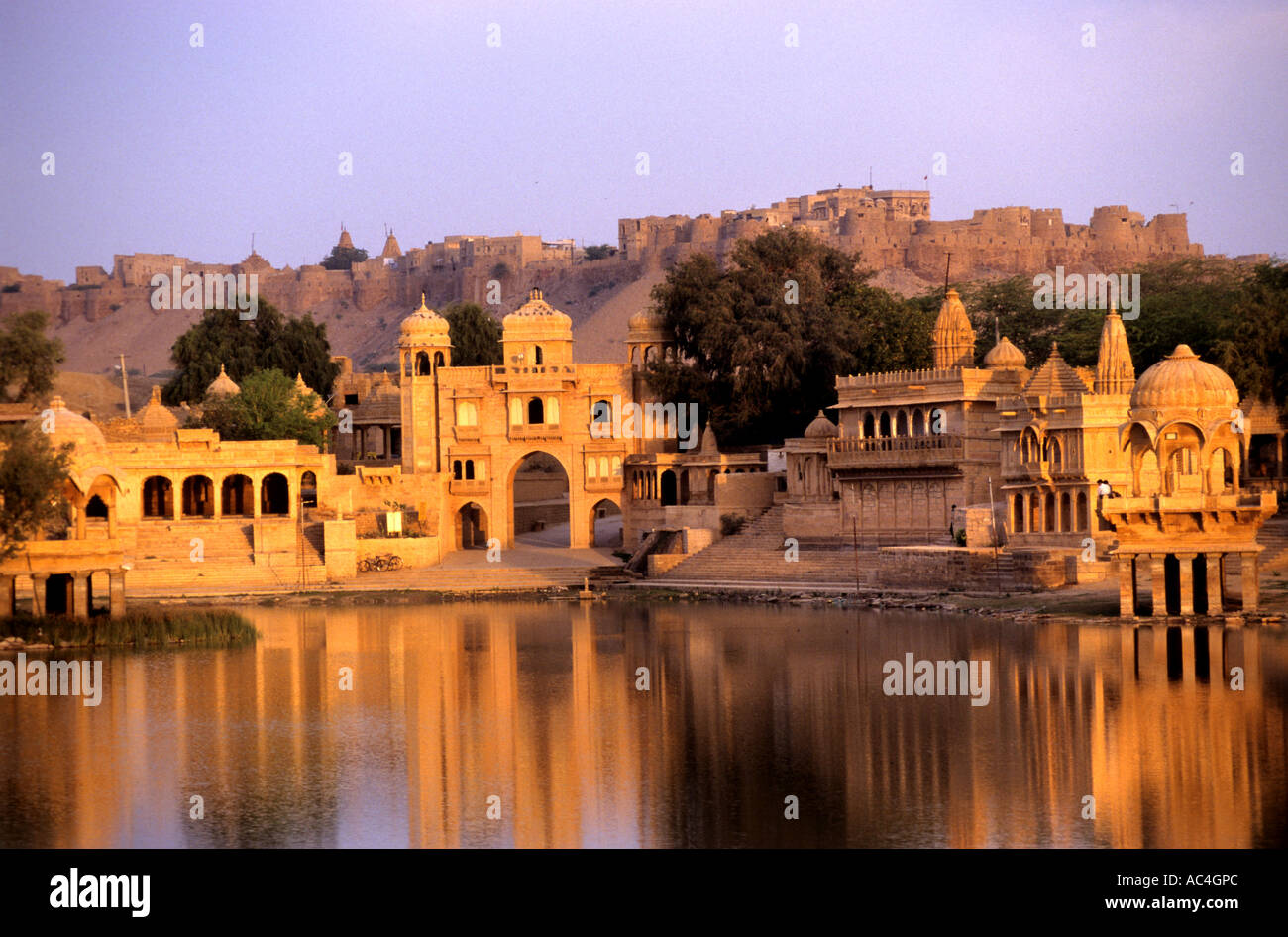 Indien Rajasthan Jaisalmer Asien Stadt Fort mit Blick auf Gadi Sagar und Thilon-Ki-Pol in der Morgendämmerung, Morgensonne rot Wasser See Stockfoto