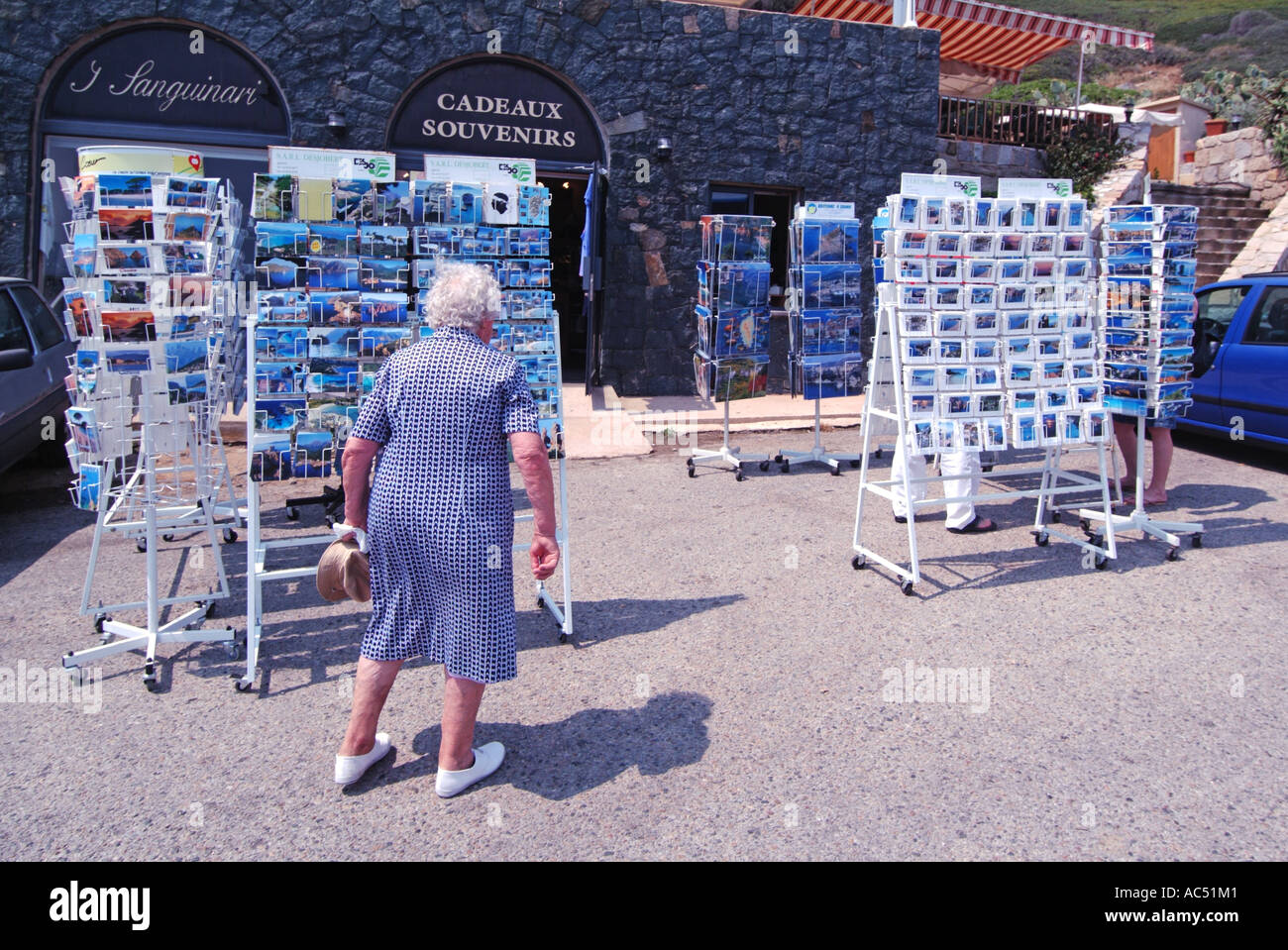 In der Nähe von Ajaccio Frau Tourist Souvenir Card Store & Outdoor Postkarten Grußkarten auf Ständern & Spinner für Menschen zu kaufen Im Shop sonniges Korsika Frankreich Stockfoto